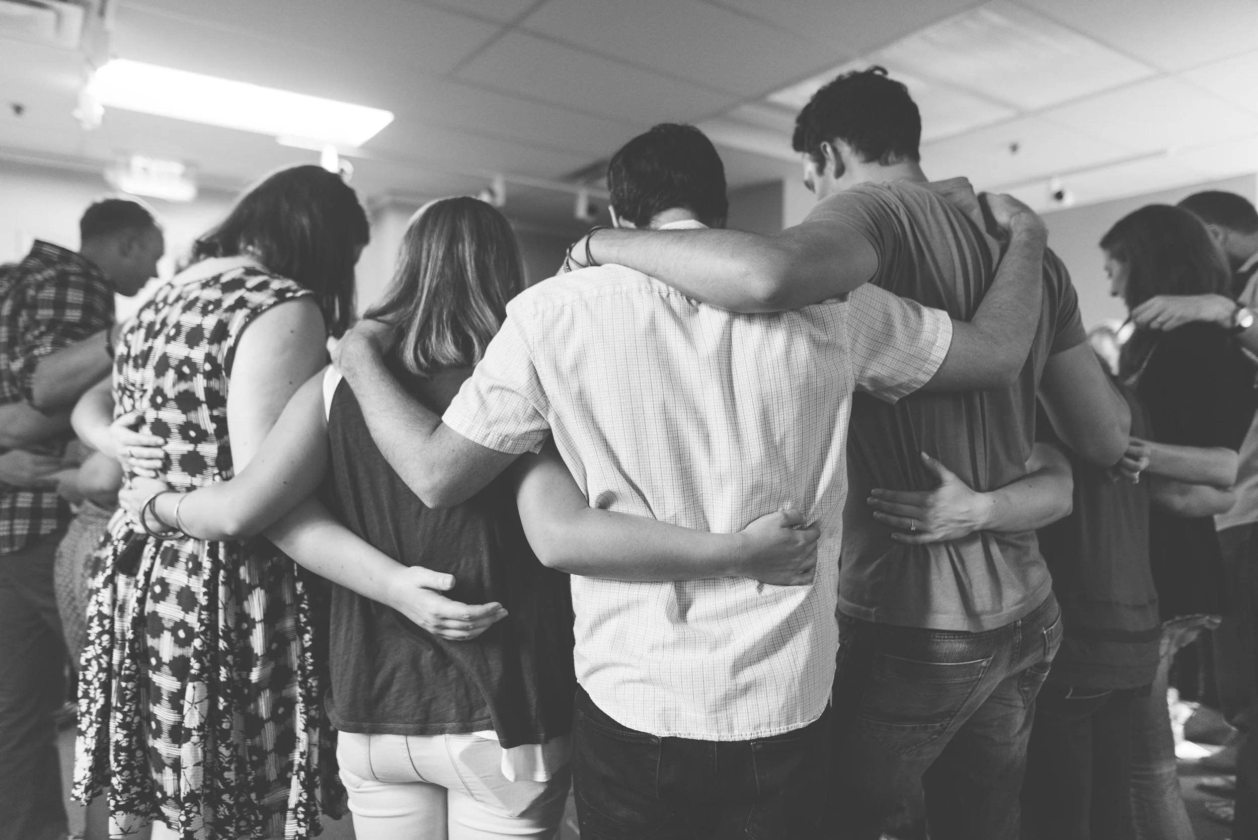 Group of people hugging in a circle at a Grace Capital City church gathering in Washington, DC.
