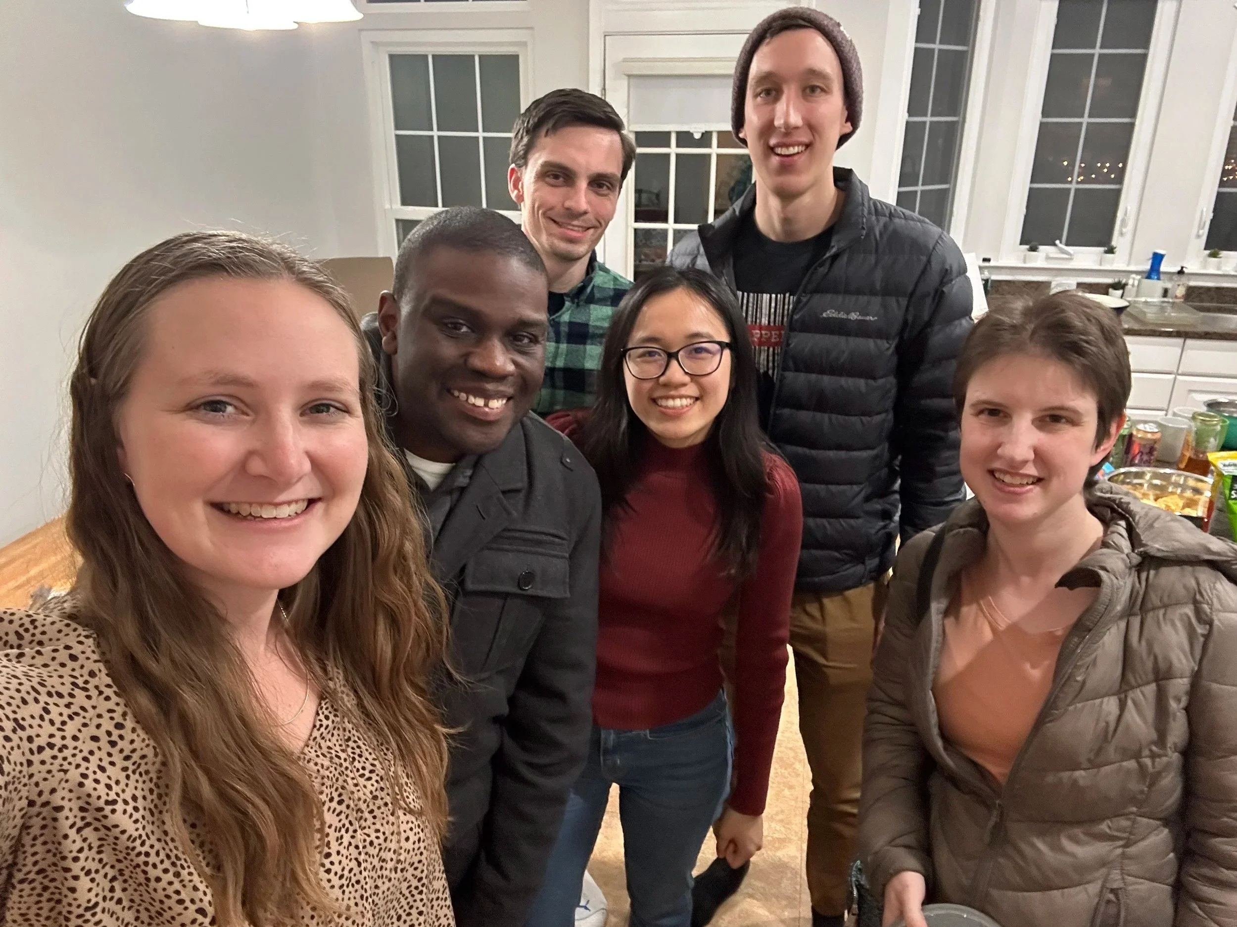 A group of seven people gathered in a kitchen, smiling and posing for a photo while serving with Grace Capital City church in Washington, DC.