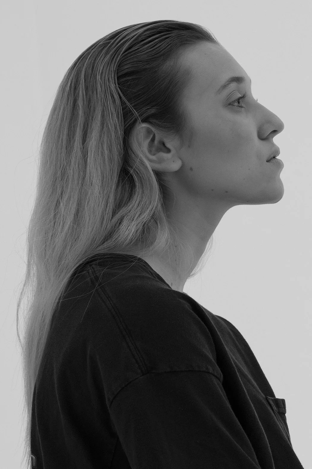 Donna con capelli lunghi lisci e capelli raccolti, vista laterale, in bianco e nero.