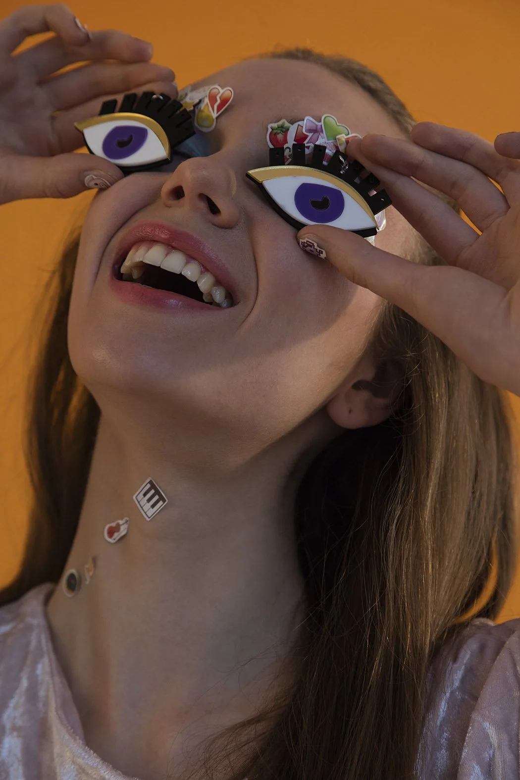 Donna con occhiali decorati con sticker colorati, che sorride e mostra i denti