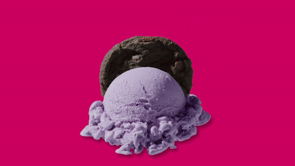 A scoop of purple ice cream with a chocolate cookie on top, against a pink background.