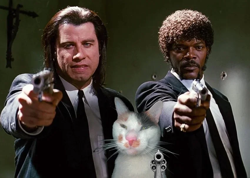 Scene from Pulp Fiction with characters holding guns, but with a cat's face edited into the middle of the image.