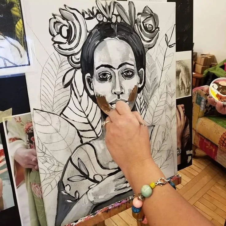Artist painting a portrait of a woman on canvas, using black, white, and brown paints, with floral elements in the background.