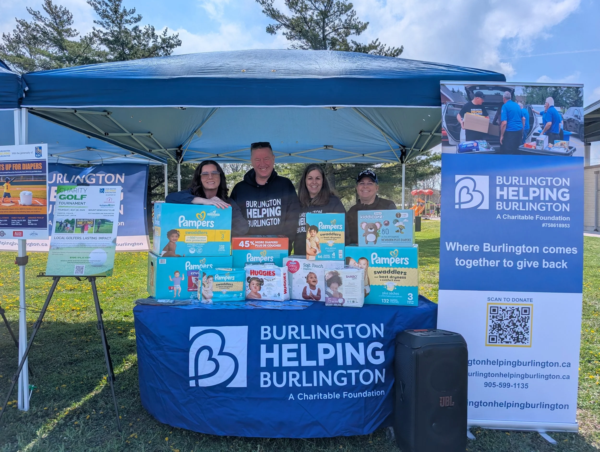 BHB members stand behind table with diapers collected as part of first-ever diaper drive for Shifra Homes and OCC (a division of R.O.C.K.) on May 5, 2025 at Sherwood Forest Baseball Park.