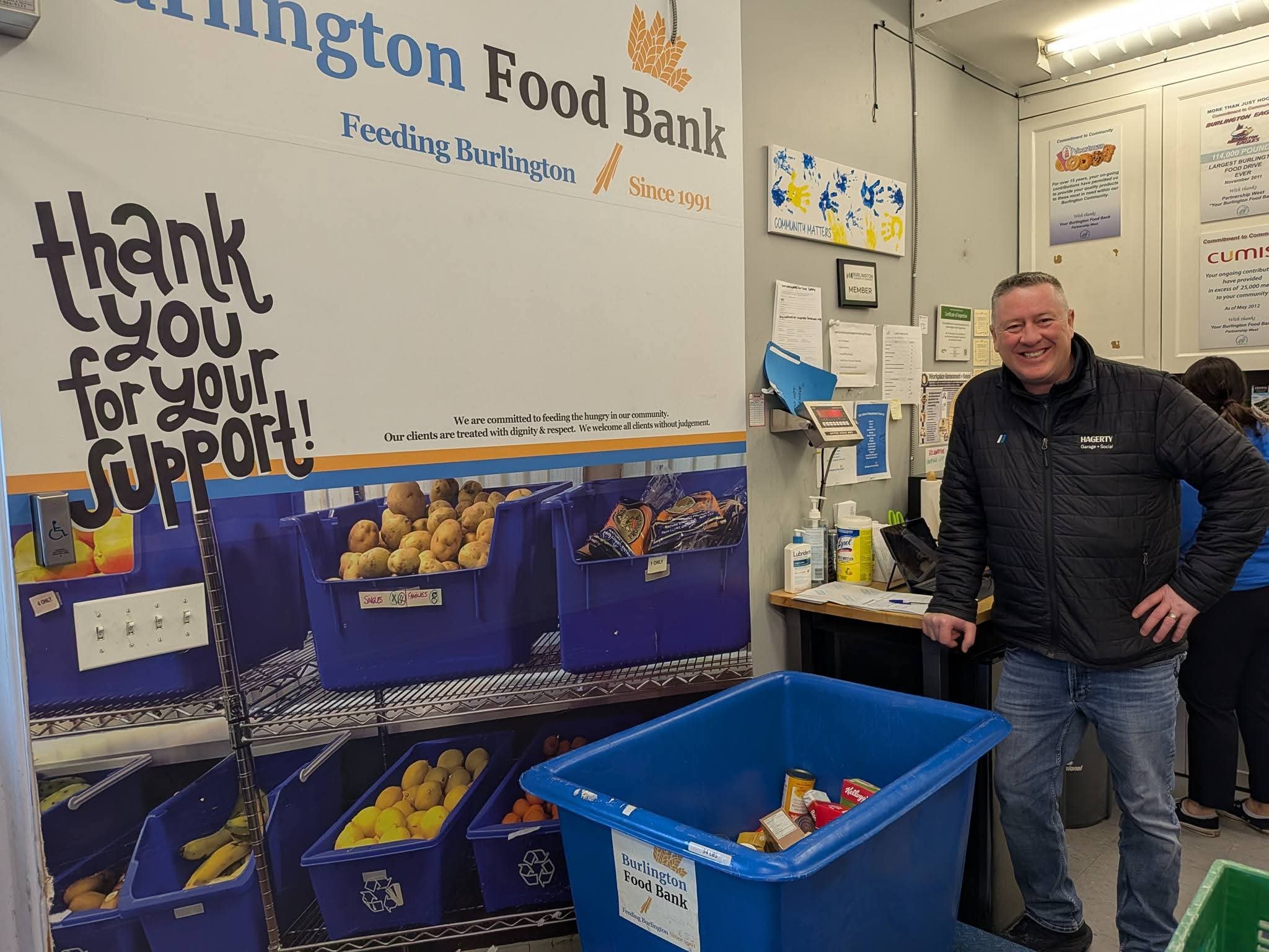 President of BHB standing with food drive donations