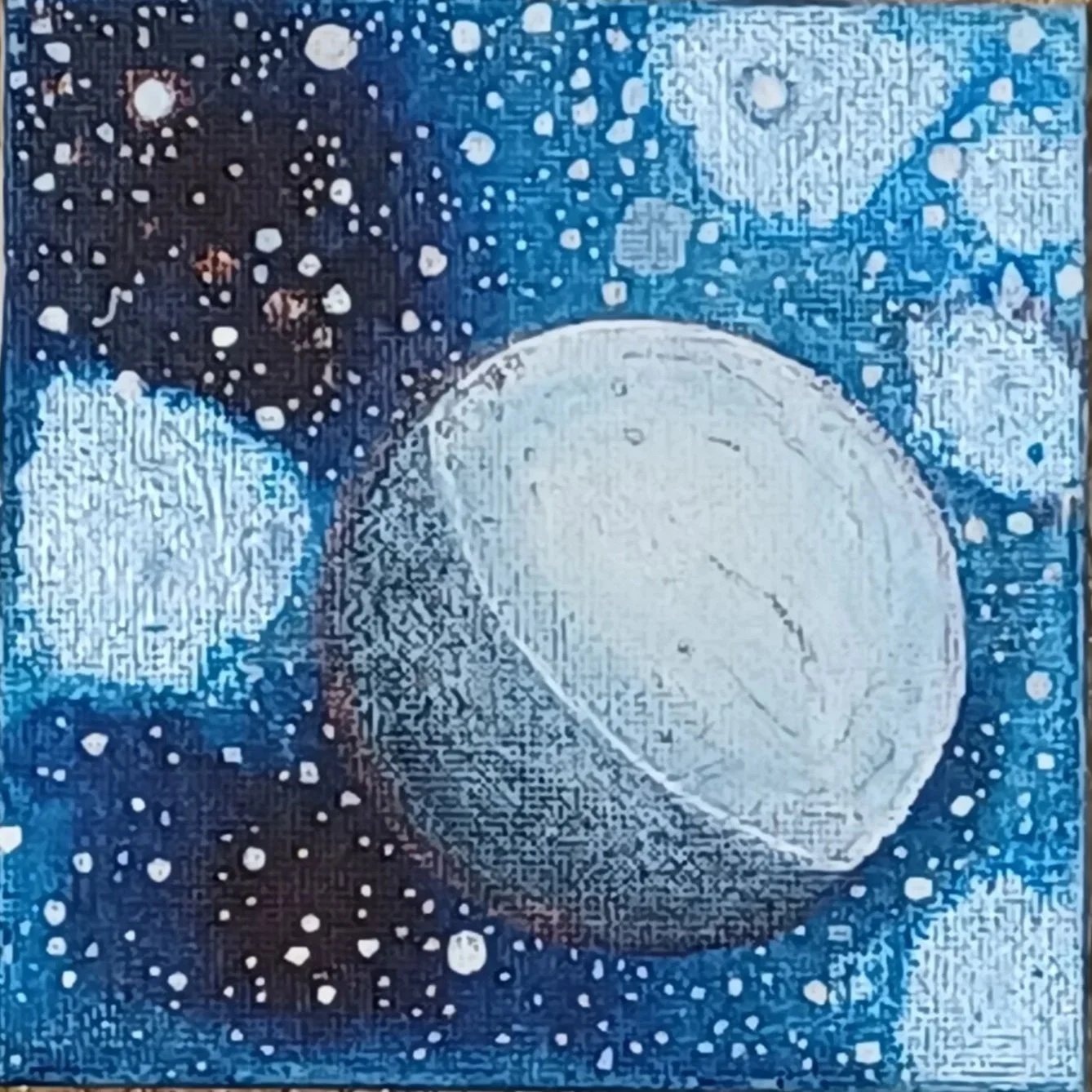 Abstract painting with large white circle, smaller white circle, surrounding dark blue background with white dots resembling stars.