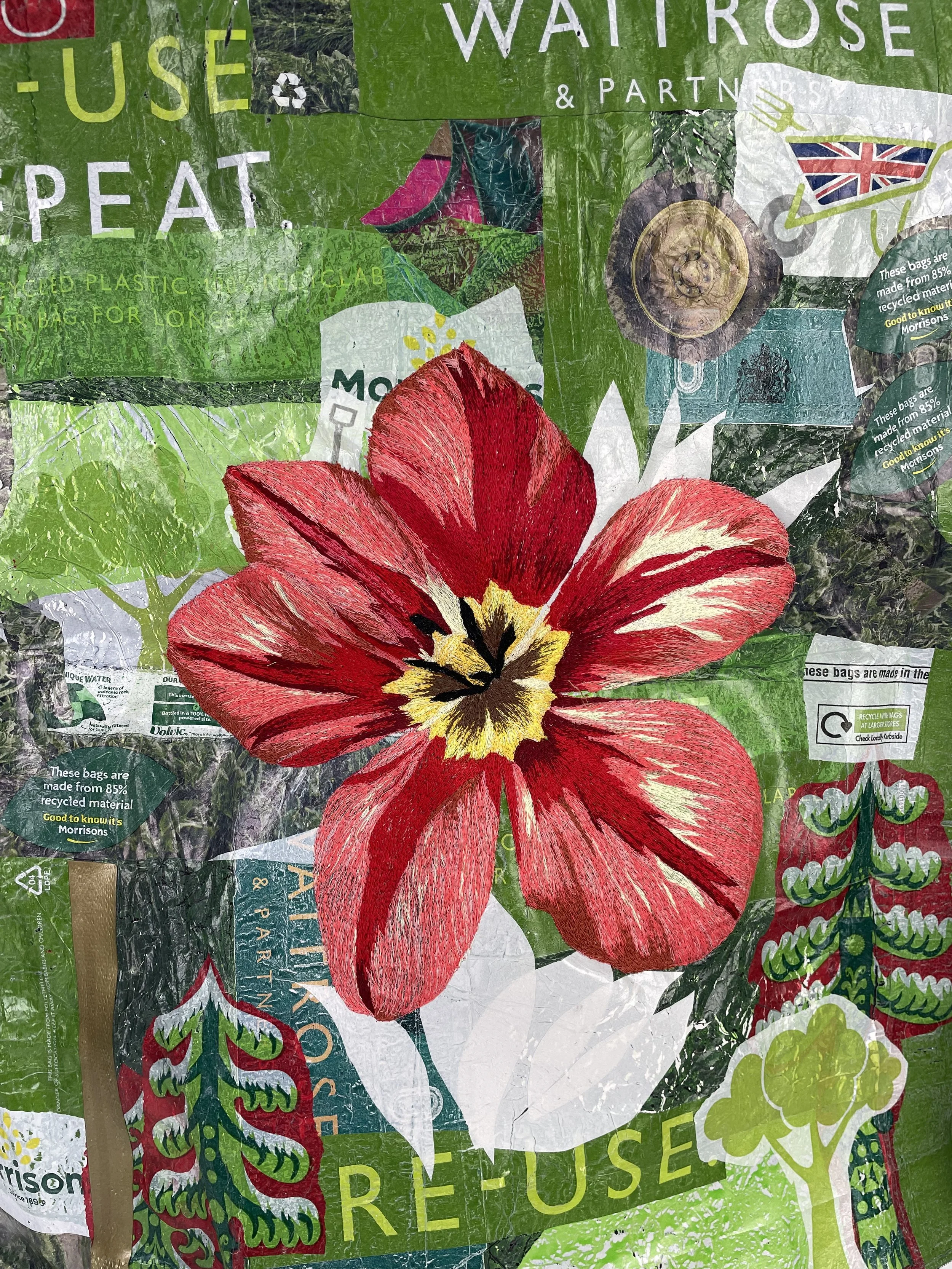 A crumpled plastic shopping bag with a large red flower design, green and white background, and text promoting reuse and recycling.