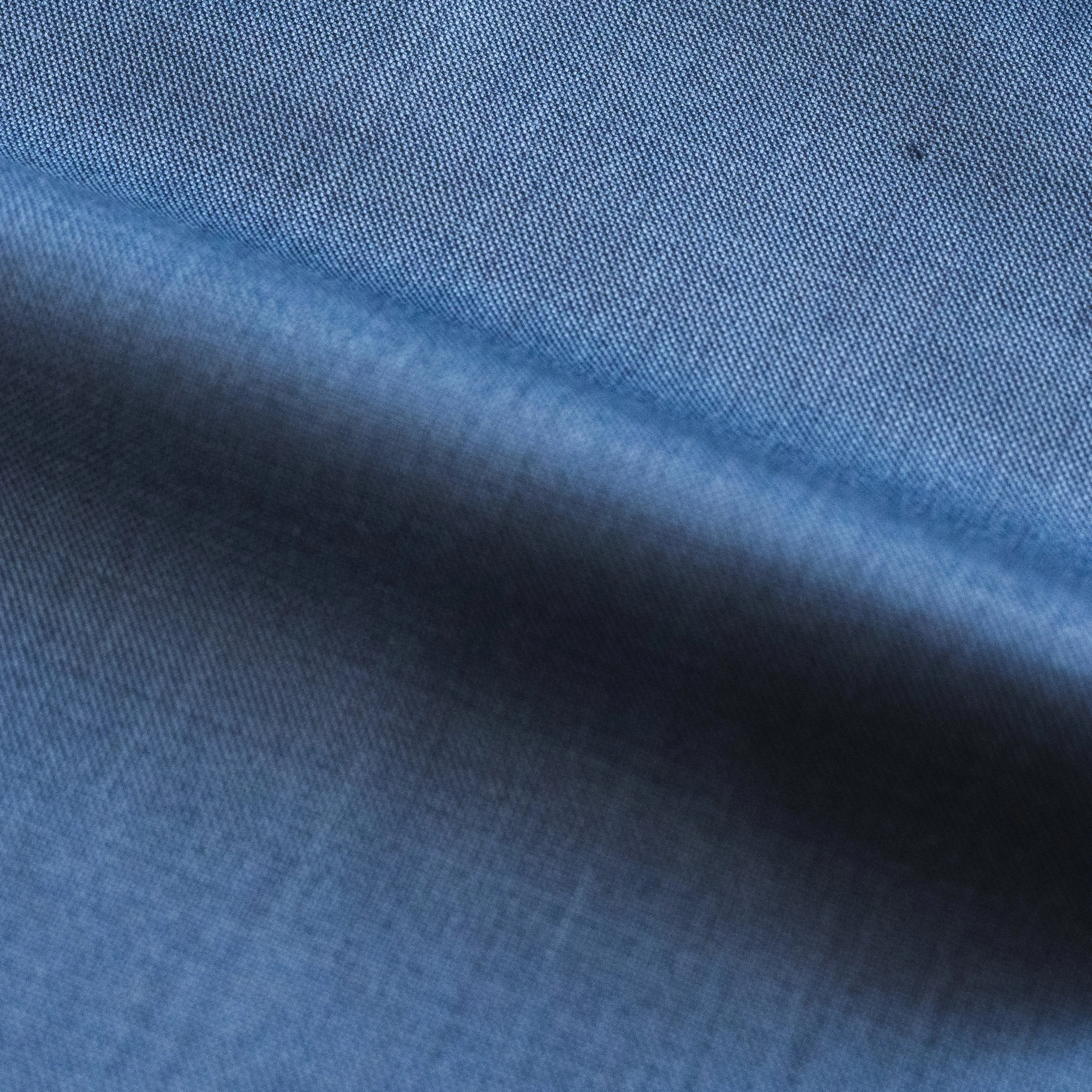 Close-up of blue fabric with a textured, woven pattern.