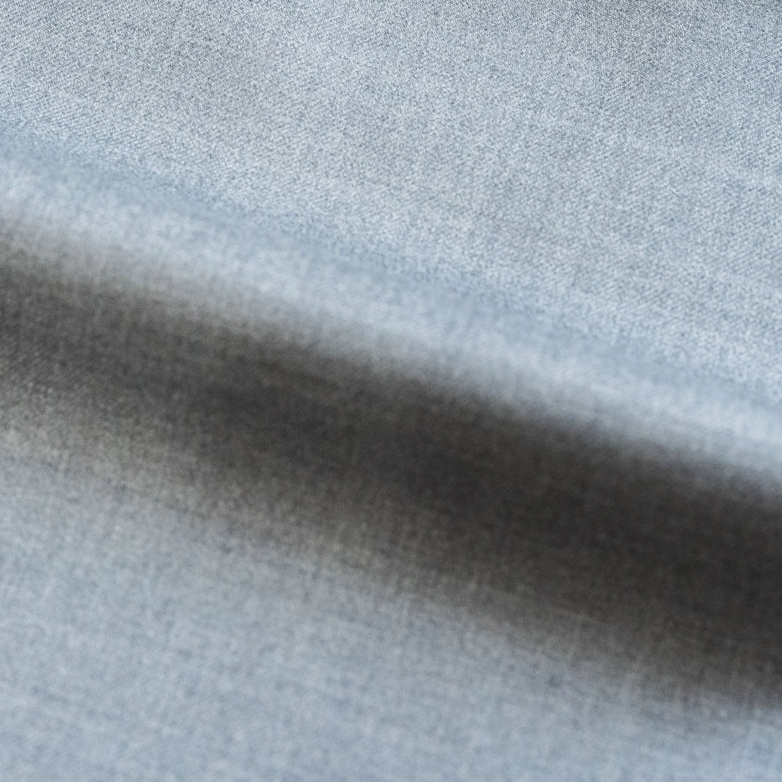 Close-up view of a textured, silver-gray fabric surface.