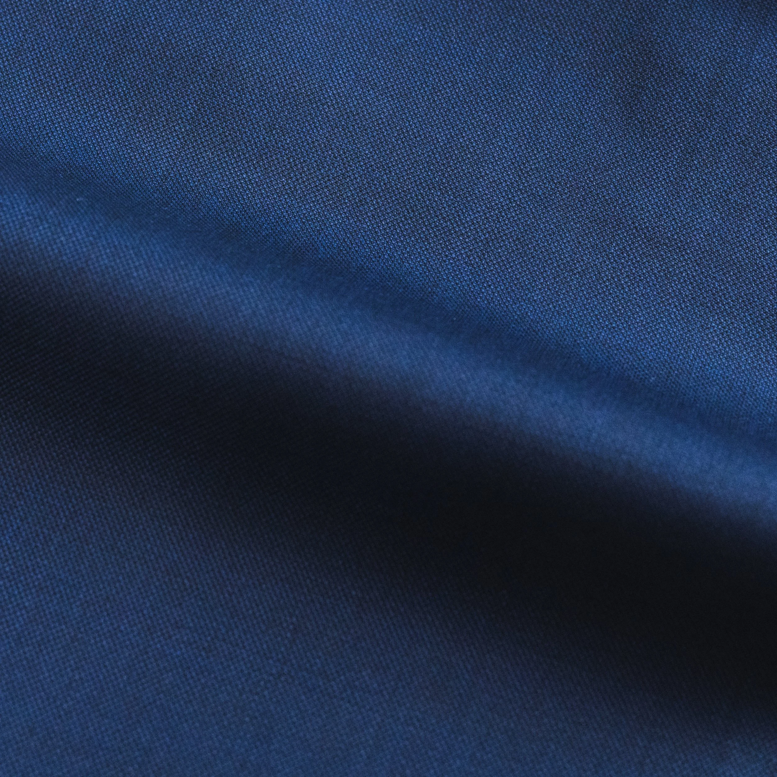 Close-up of a dark blue fabric surface with a micro-textured appearance.