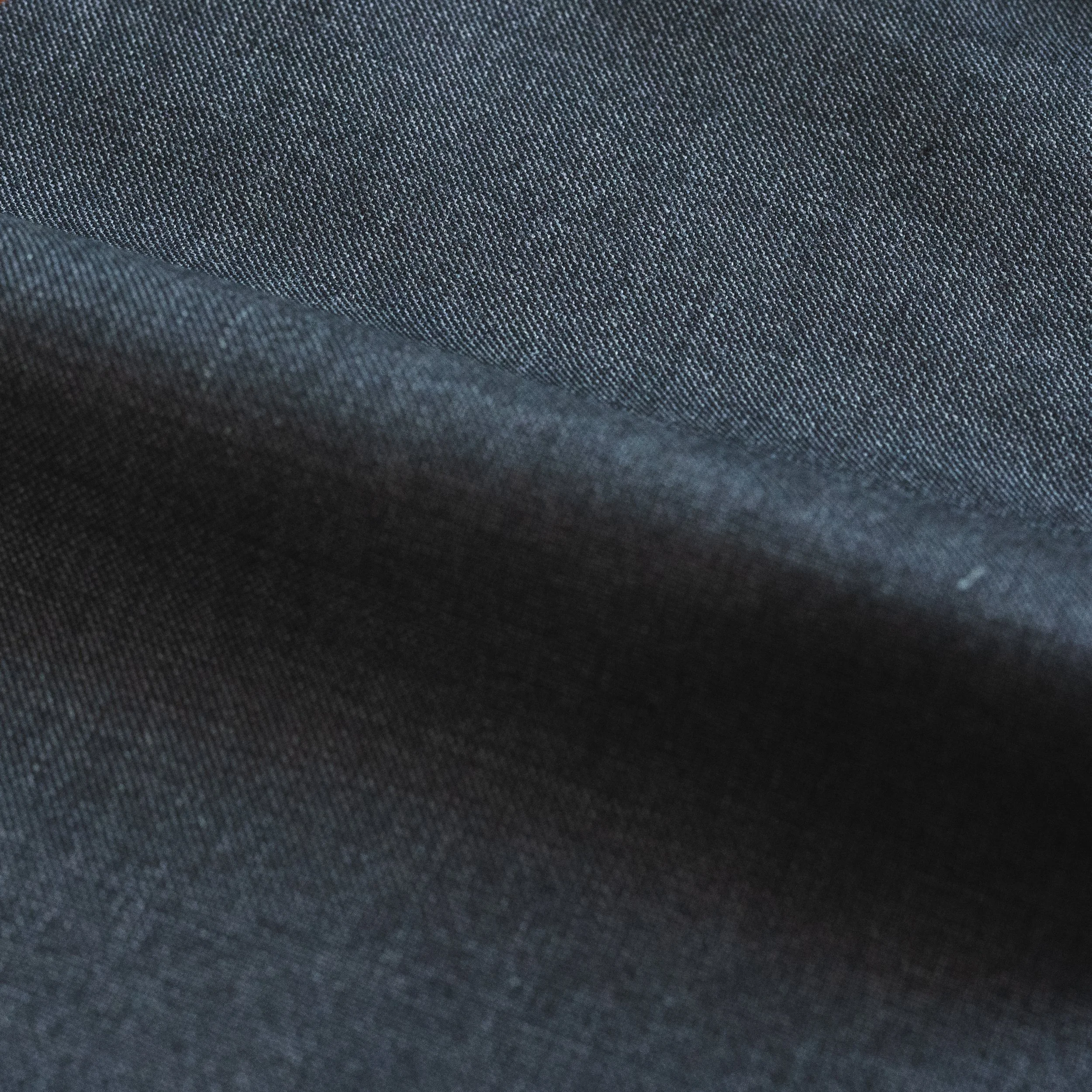 Close-up of dark gray textured suit fabric.