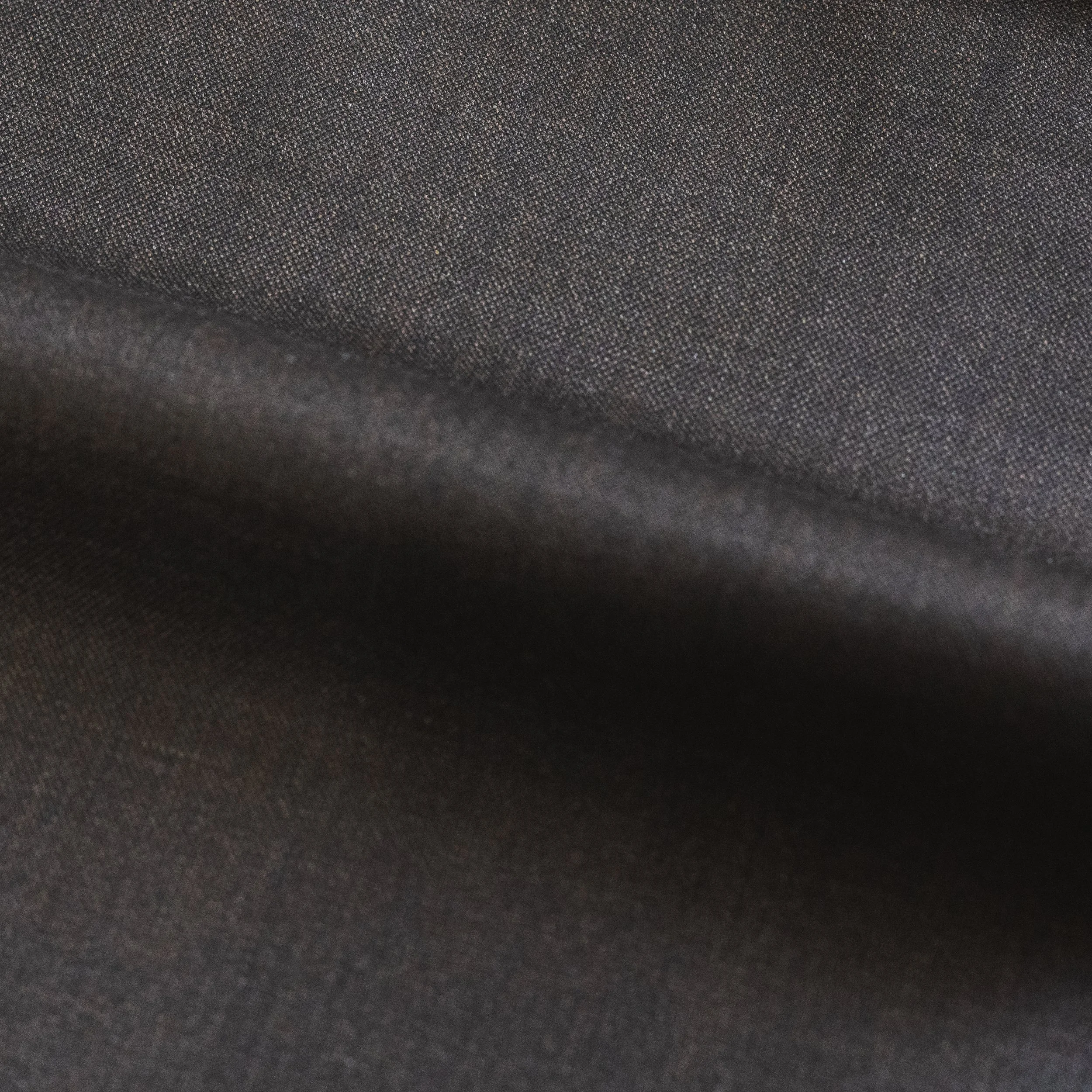 Close-up of a textured dark gray fabric surface.