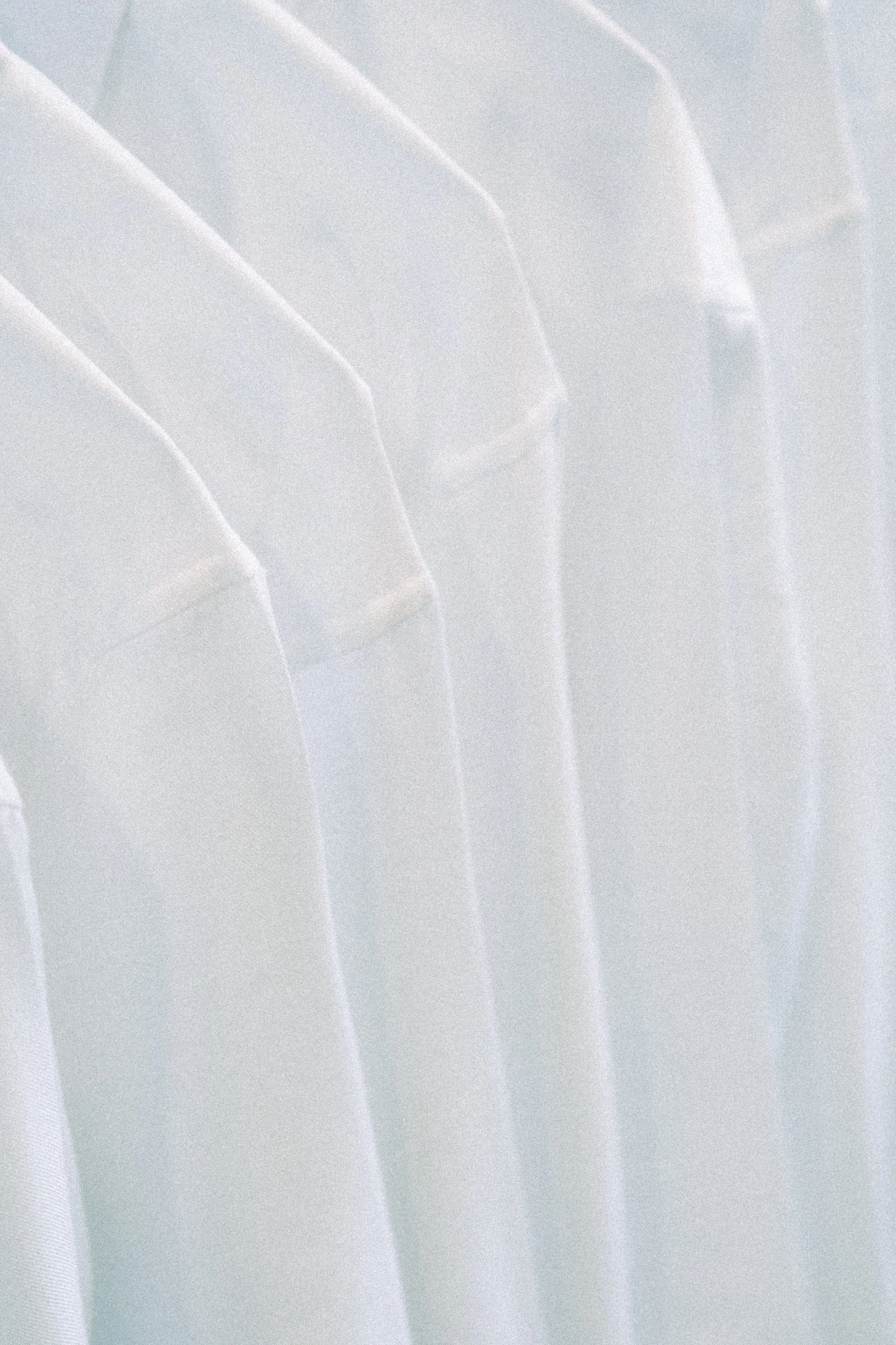 Close-up of white dress shirts hanging on a rack in a store.