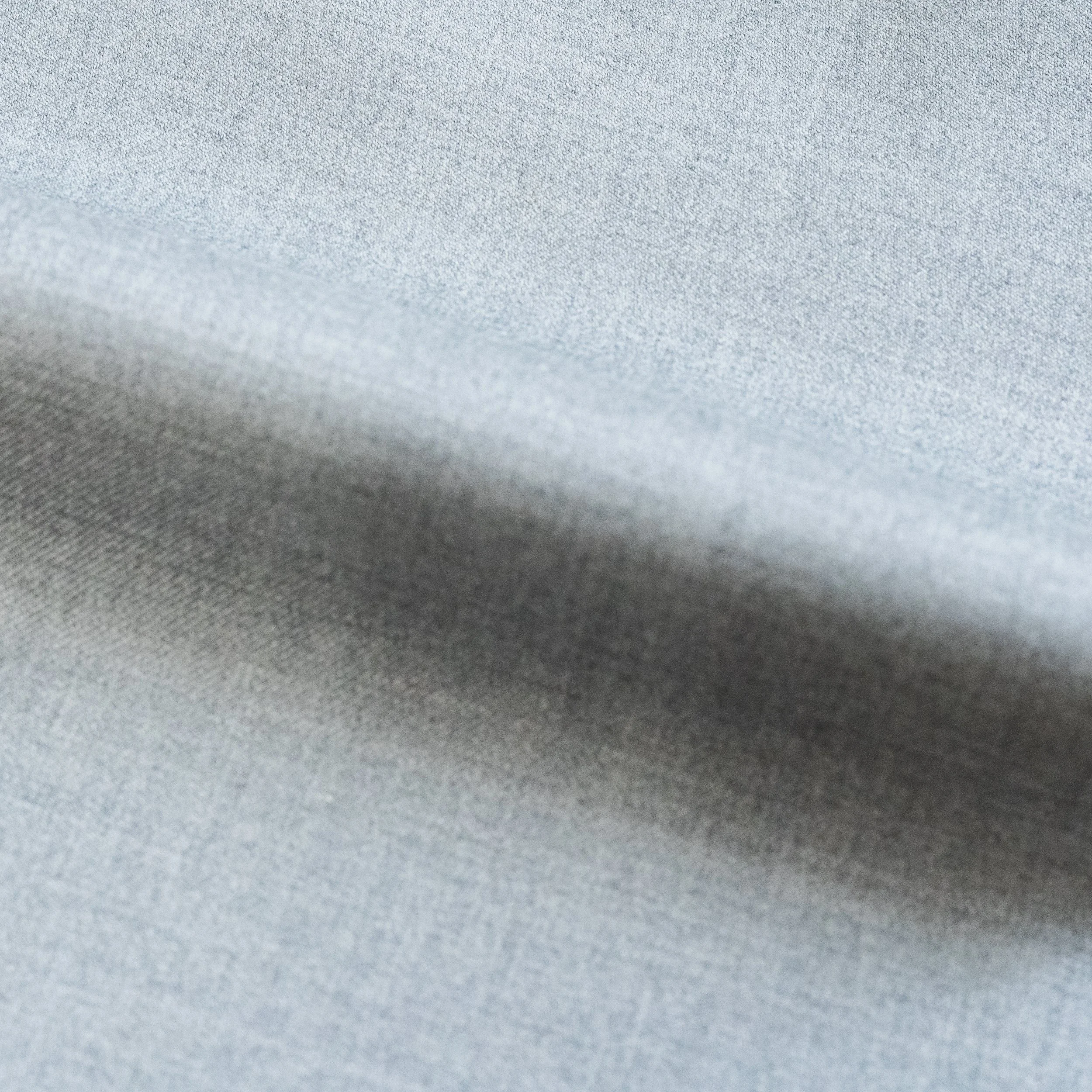 Close-up of a textured, light gray fabric surface.