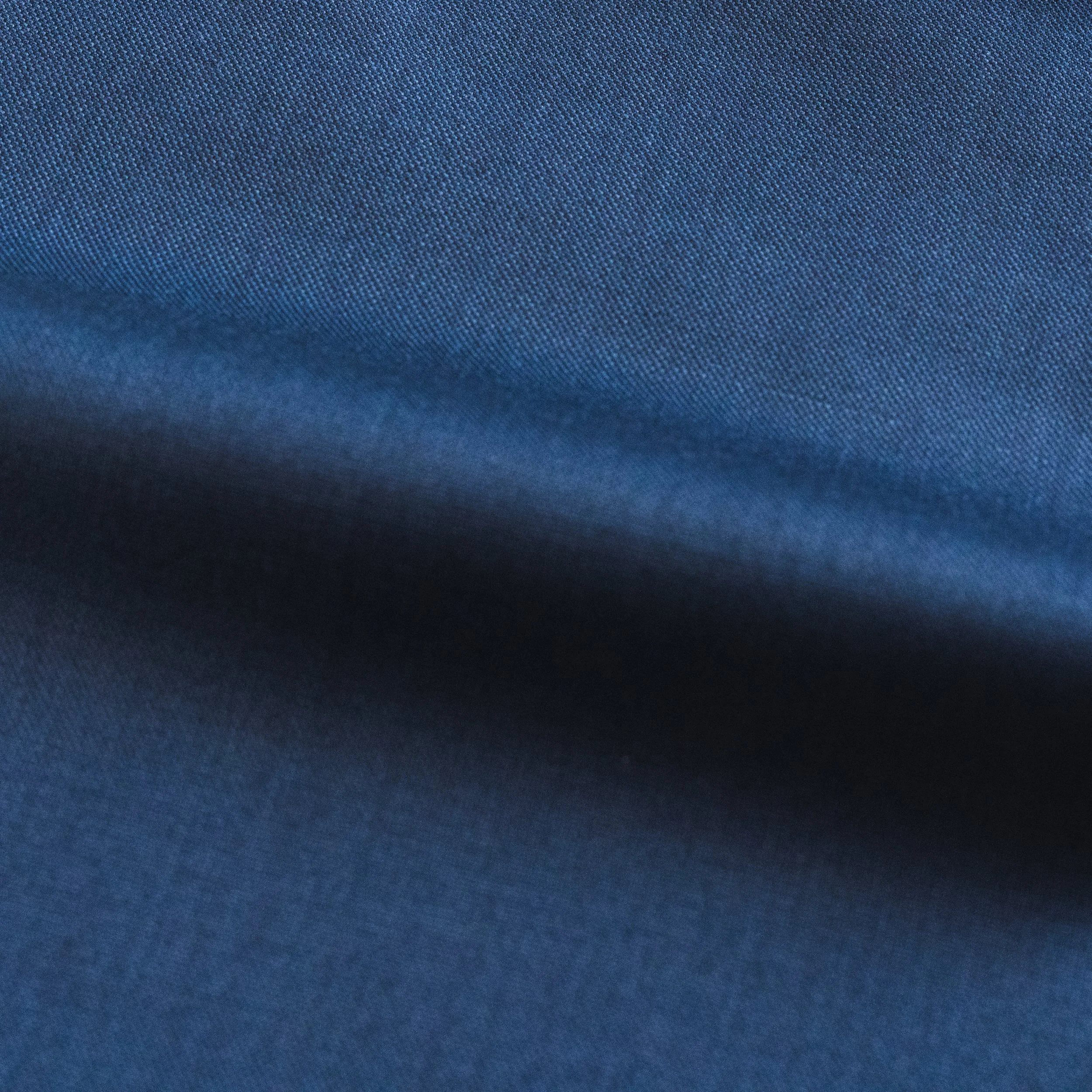 Close-up view of a blue fabric with fine, tight weave and texture.