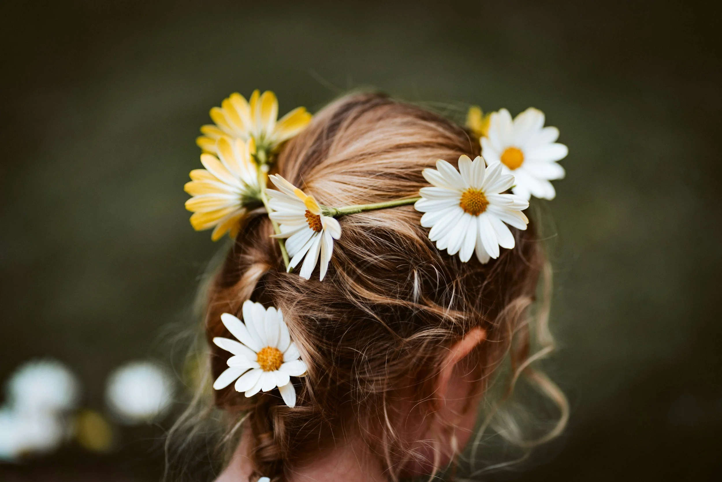 Person with red hair wearing a daisy flower crown.