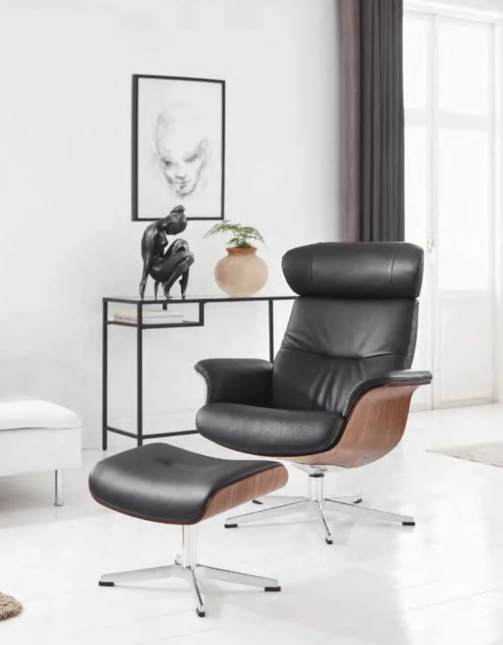 Sleek black and bent-wood modern recliner & ottoman by Conform Collection AB in minimalist living room