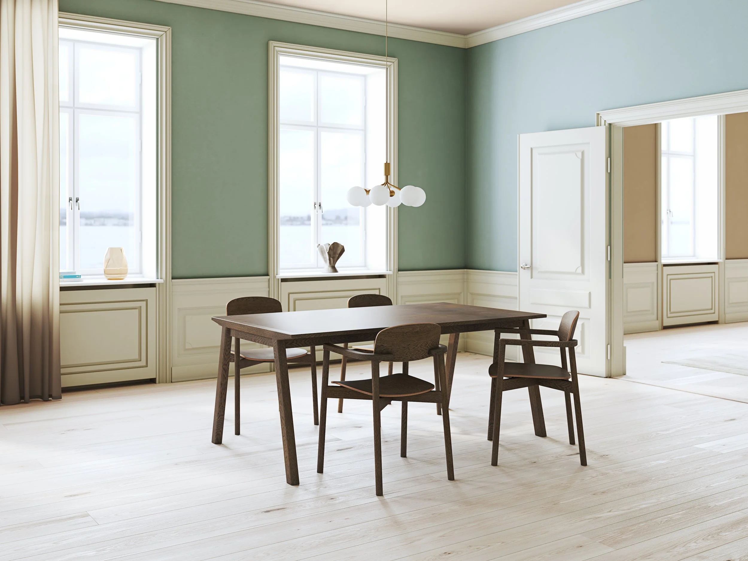 Bright dining room with pale green walls, white trim, a wooden dining table, four matching chairs, and a modern chandelier with globe lights, overlooking a body of water through large windows.