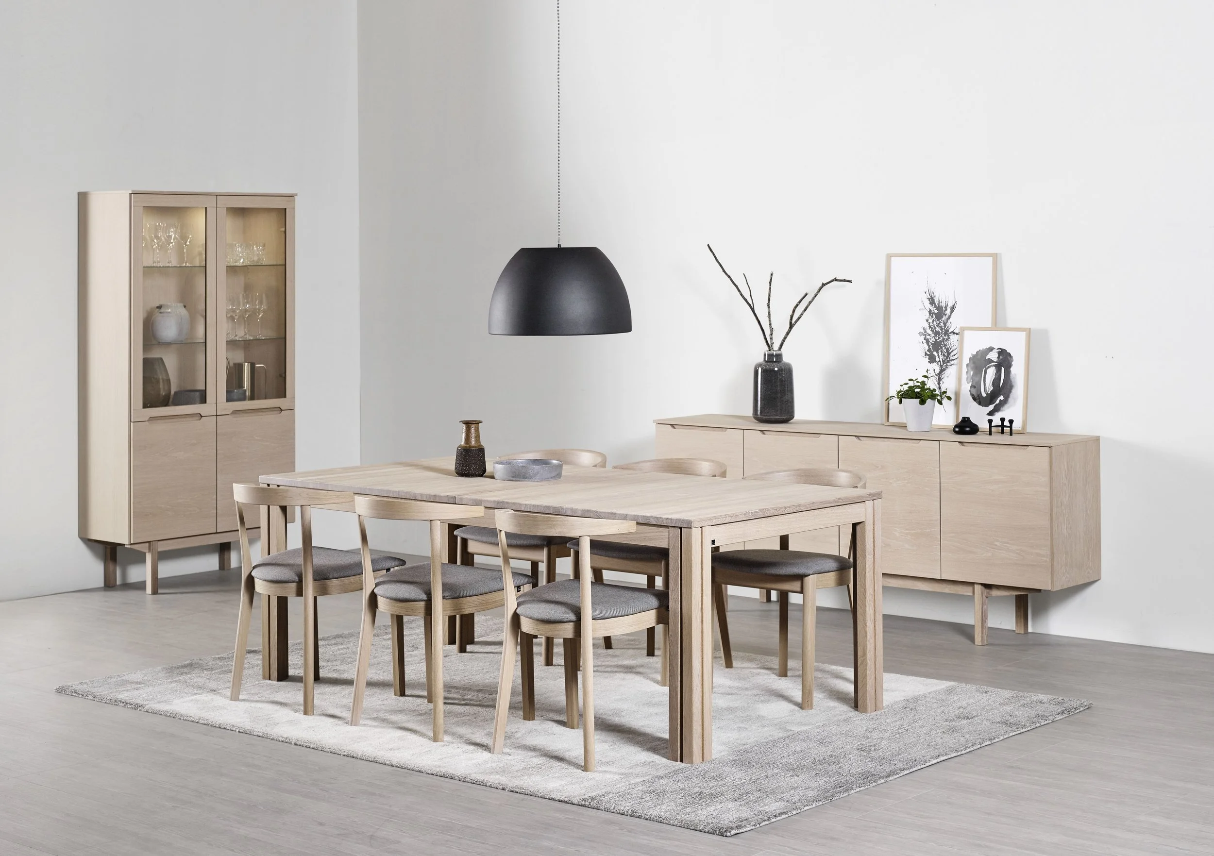 Scandinavian-style dining room with a light oak wood table and six matching chairs with gray cushions, a light wood sideboard, and a glass cabinet by Skovby Furniture from Denmark