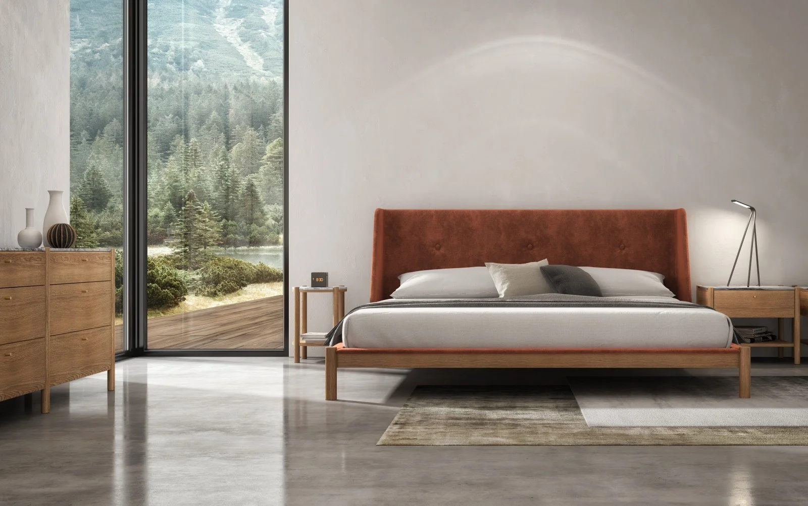 Modern bedroom with a large bed with orange headboard, side table with lamp, a wooden dresser with vases, and a large window showing a forest landscape.