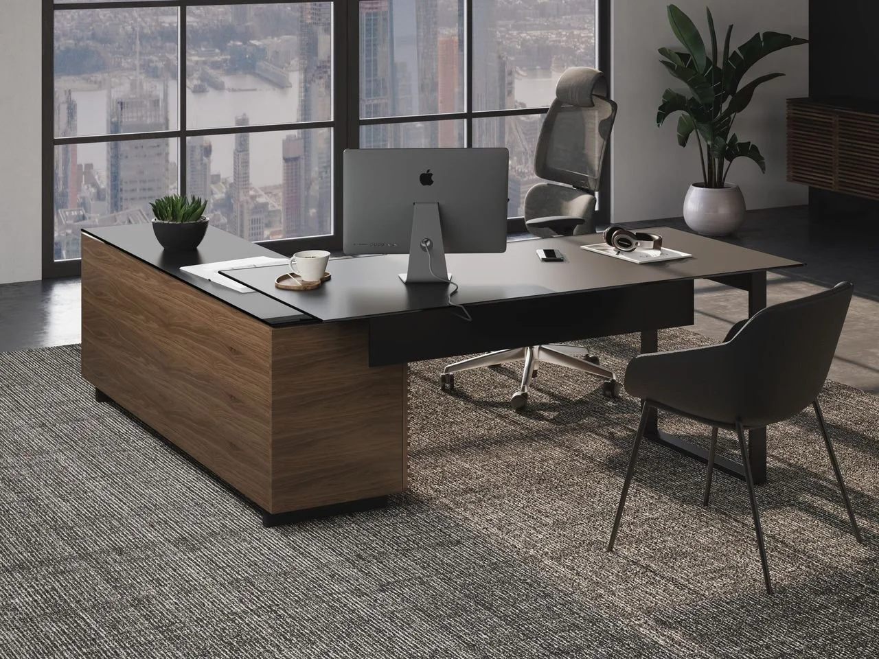 Modern office with large window overlooking city skyline, executive desk with a computer, potted plant, coffee mug, headphones, and chair, all with natural light streaming in.