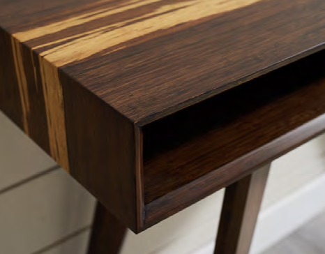 Close-up of a wooden table with a hollow shelf and a striped pattern on the surface.