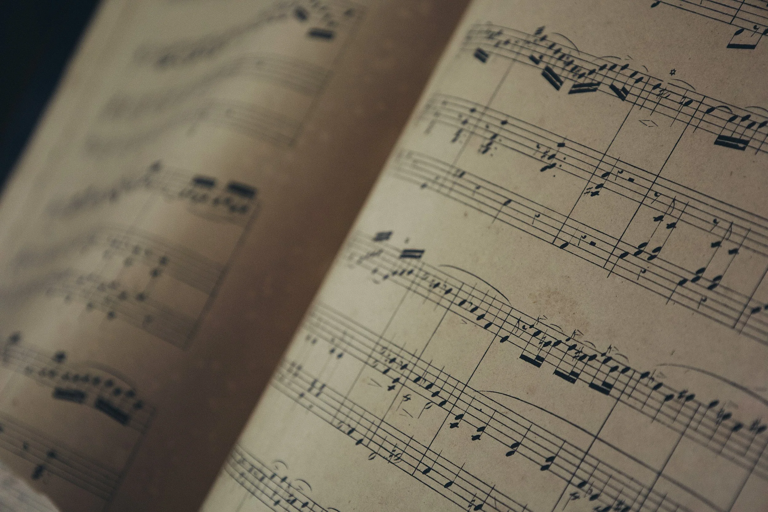 Close-up of a sheet of vintage music notation with handwritten musical notes and staff lines.