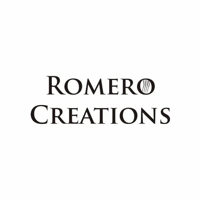 Logo of Romero Creations with a black circular design in the letter O of Romero.