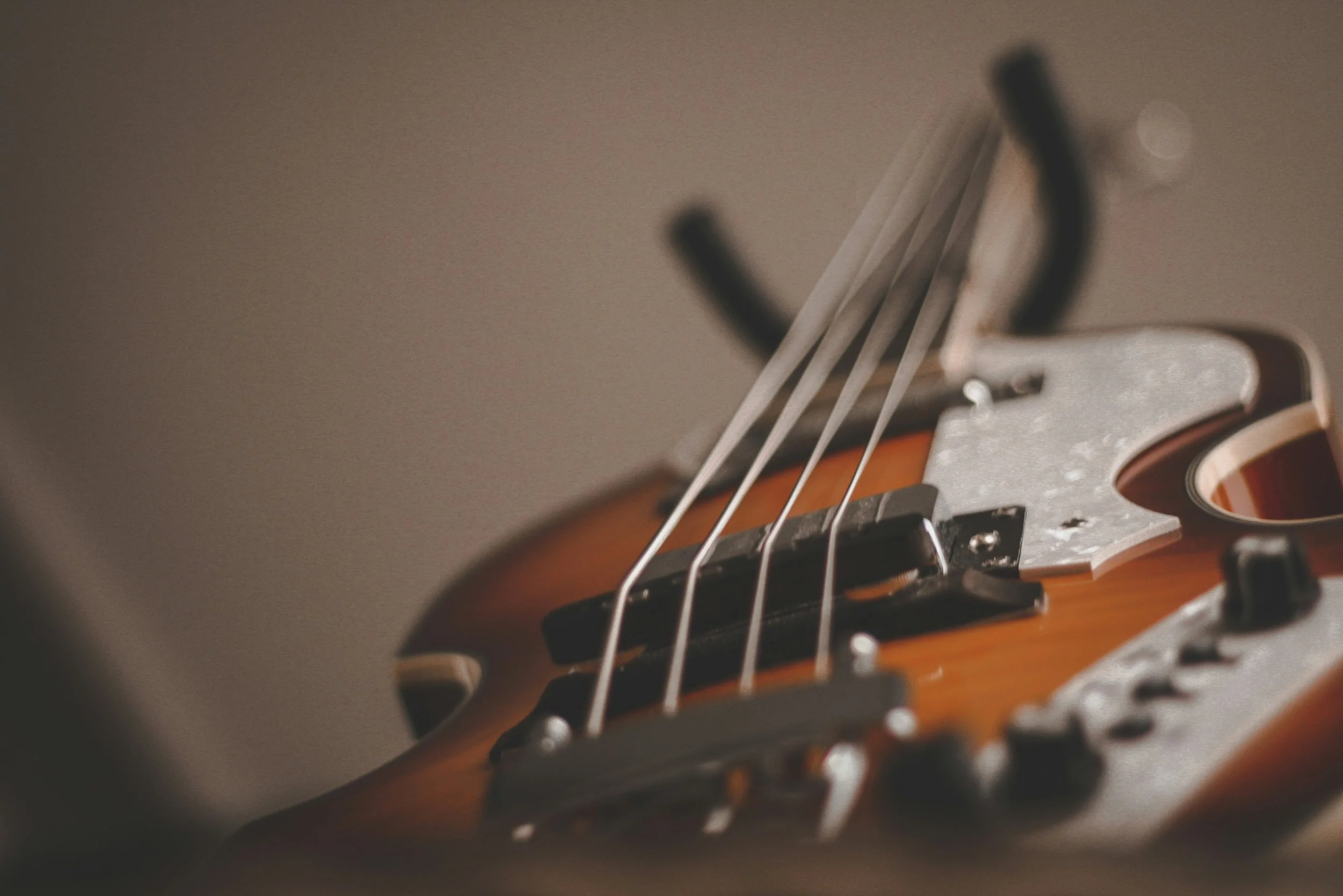 Close-up of an electric guitar's bridge and strings.