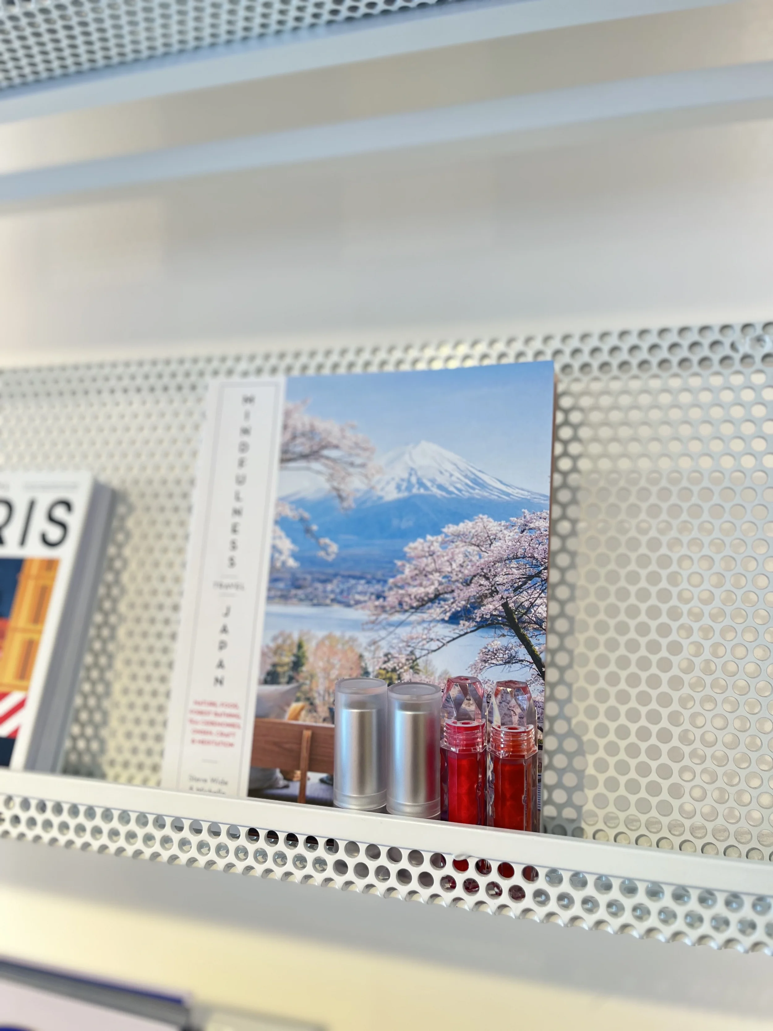 Chulip lip gloss and lip balm tubes displayed on a white shelf alongside a Mount Fuji cherry blossom postcard — Chulip super versatile lip care products