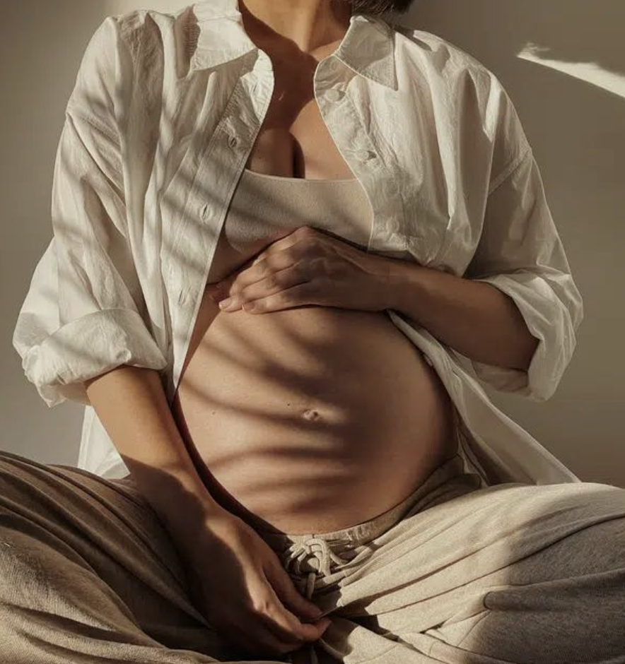 A pregnant woman who is receiving birth doula services by Emily Schalick at YOUniversal Healing.
