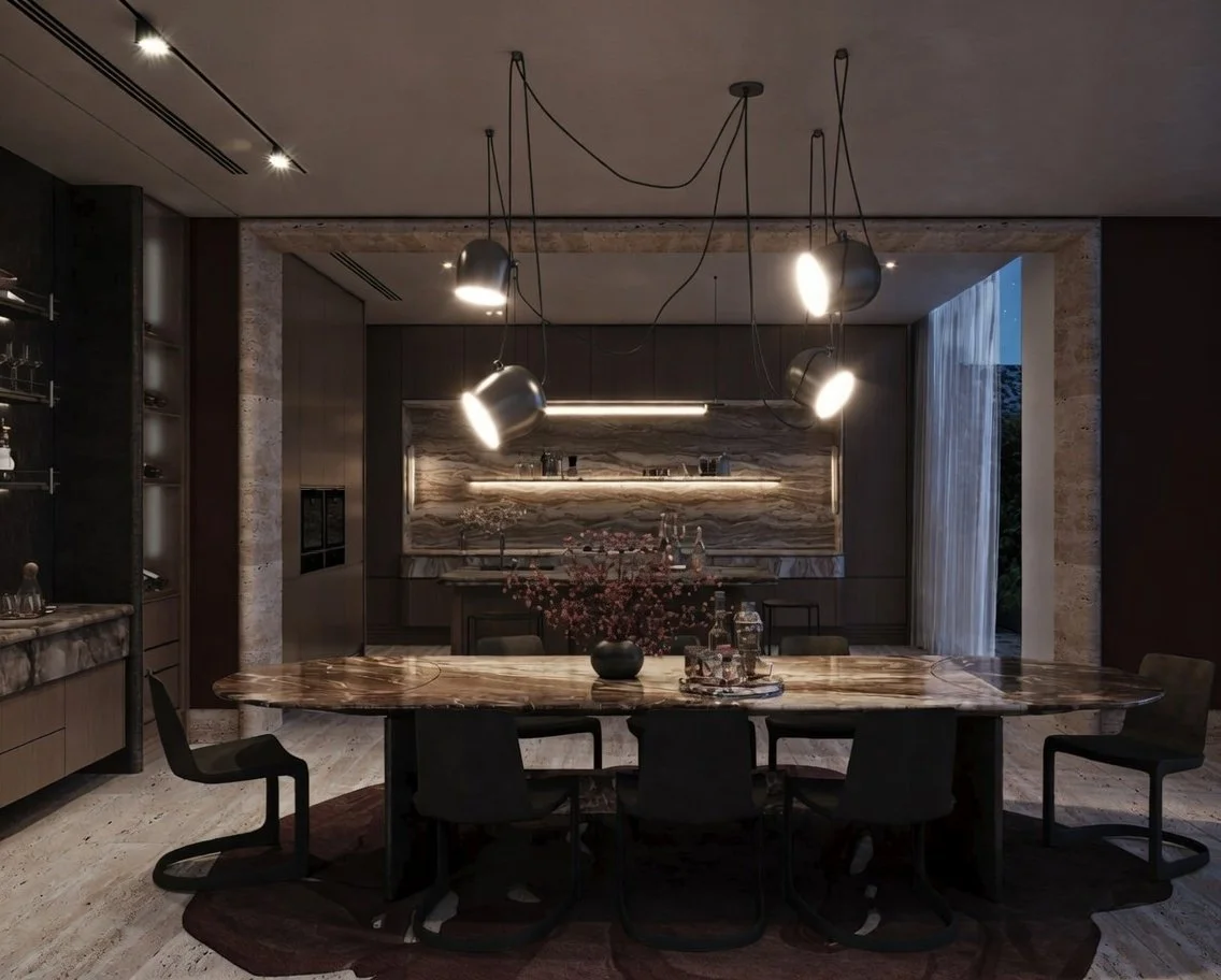 Modern dining room with a large oval marble table, black chairs, pendant lights hanging from the ceiling, and a marble backsplash in the kitchen area.