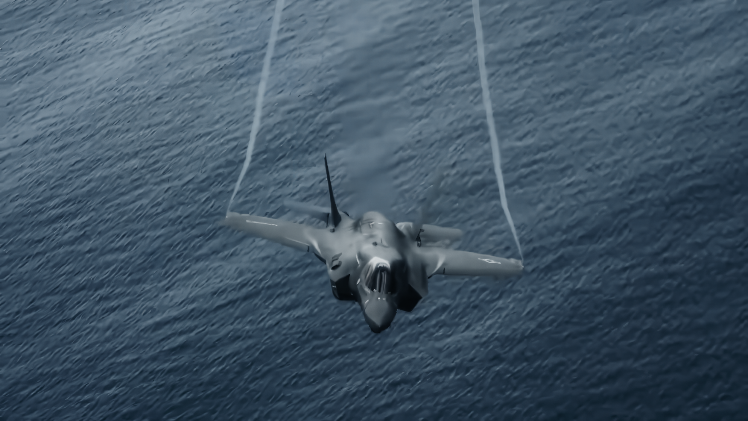 A fighter jet flying at high altitude over the ocean.