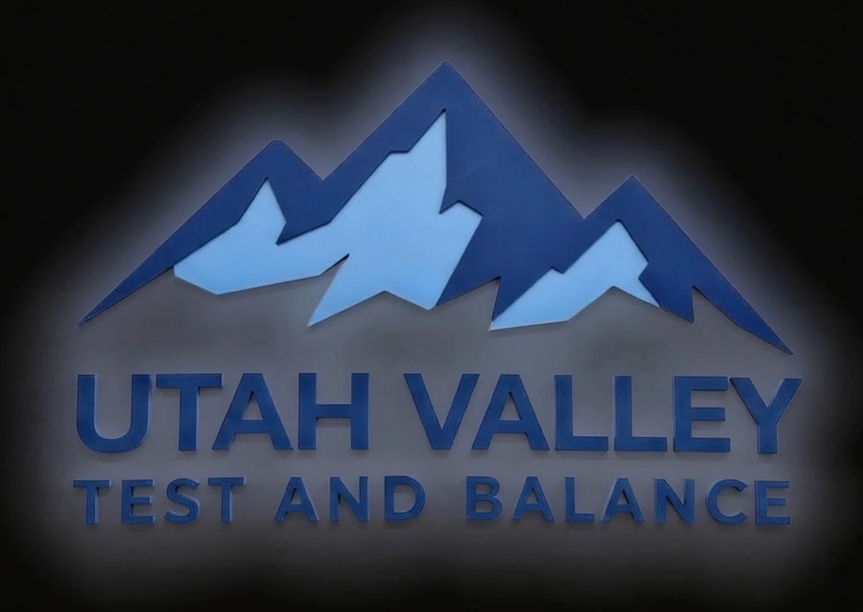 Sign with blue stylized mountain peaks and text 'UTAH VALLEY TEST AND BALANCE' in blue letters.