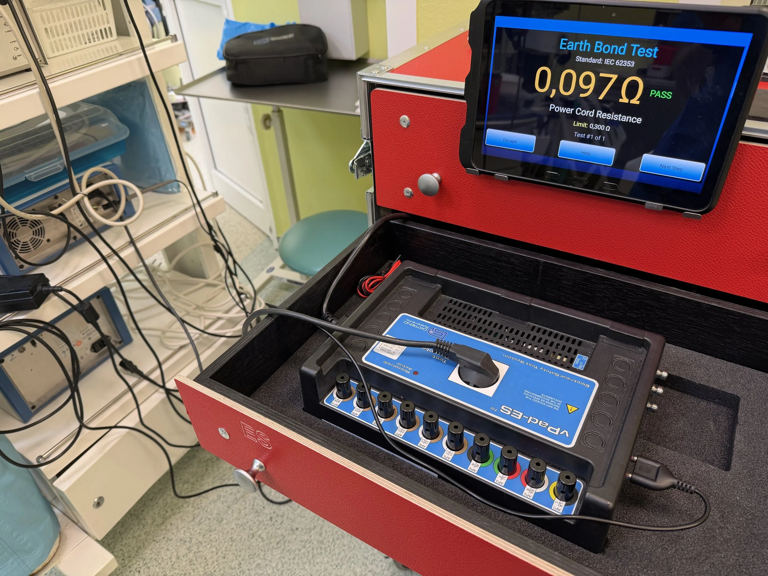tester bezpieczeństwa elektrycznego podłączony do aparatury medycznej pokazuje wynik pomiaru 0,097 Ohm. Na zielono komunikat PASS.