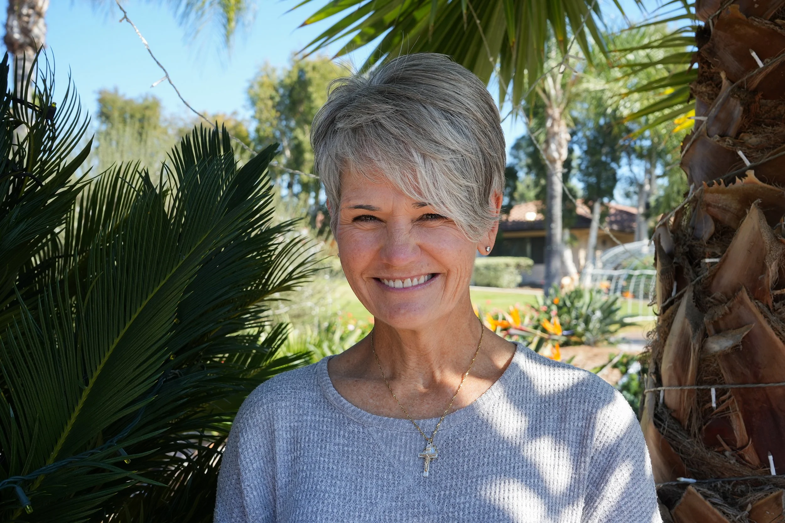 Headshot of woman standing by palm trees