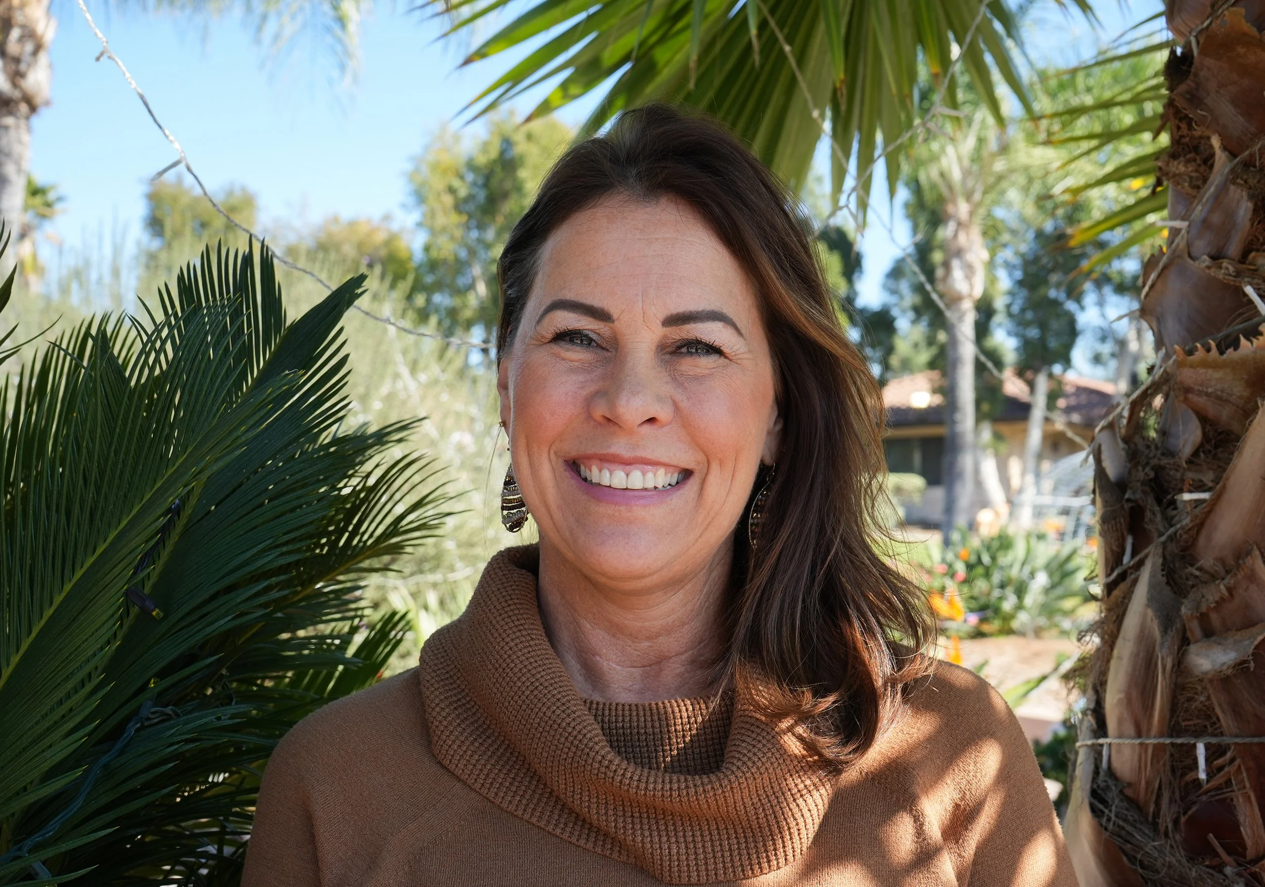 Headshot of woman standing by palm trees