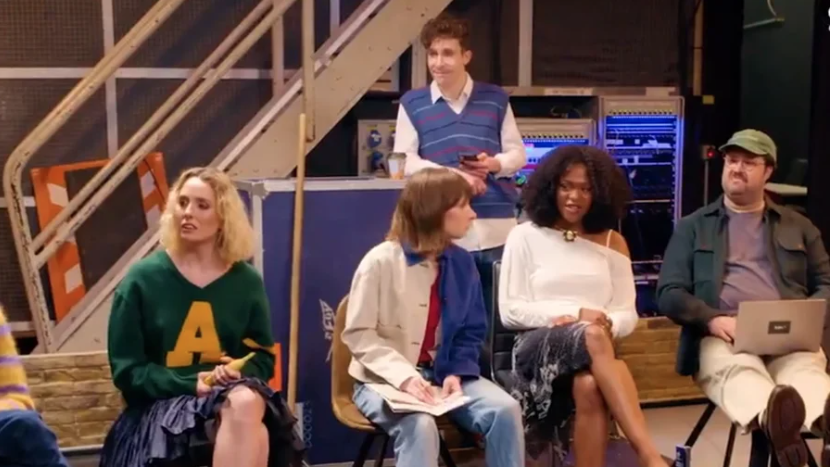 The cast of SNL UK sit around an undressed set, waiting for Tina Fey to spoon-feed them the art of comedy.