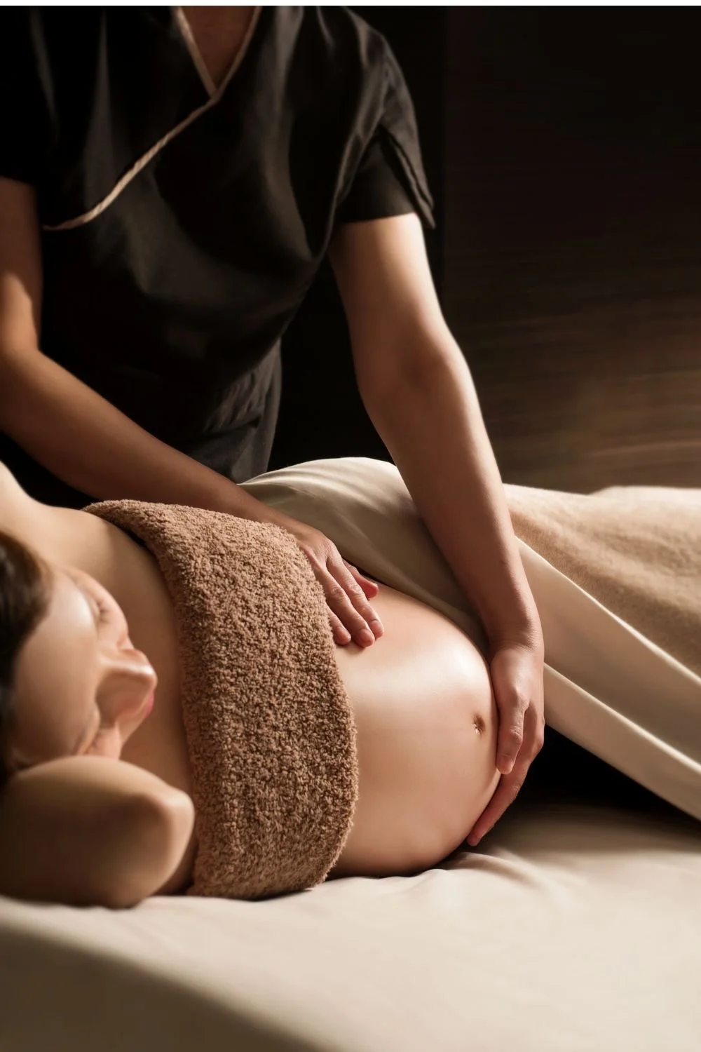 Une femme reçoit un massage de ventre dans un spa ou centre de bien-être.