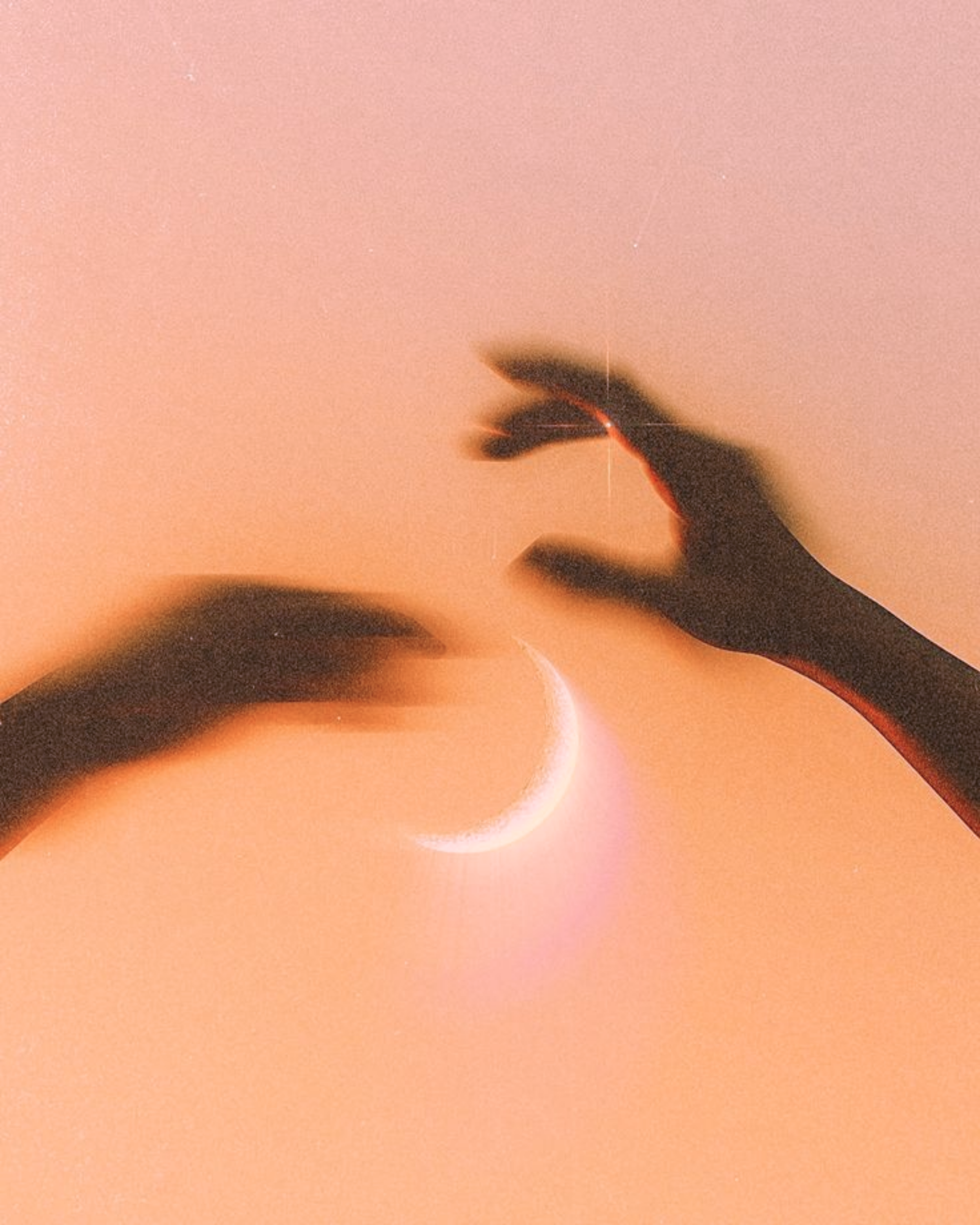 Silhouette of a hand reaching toward a crescent moon against a peach-colored sky.