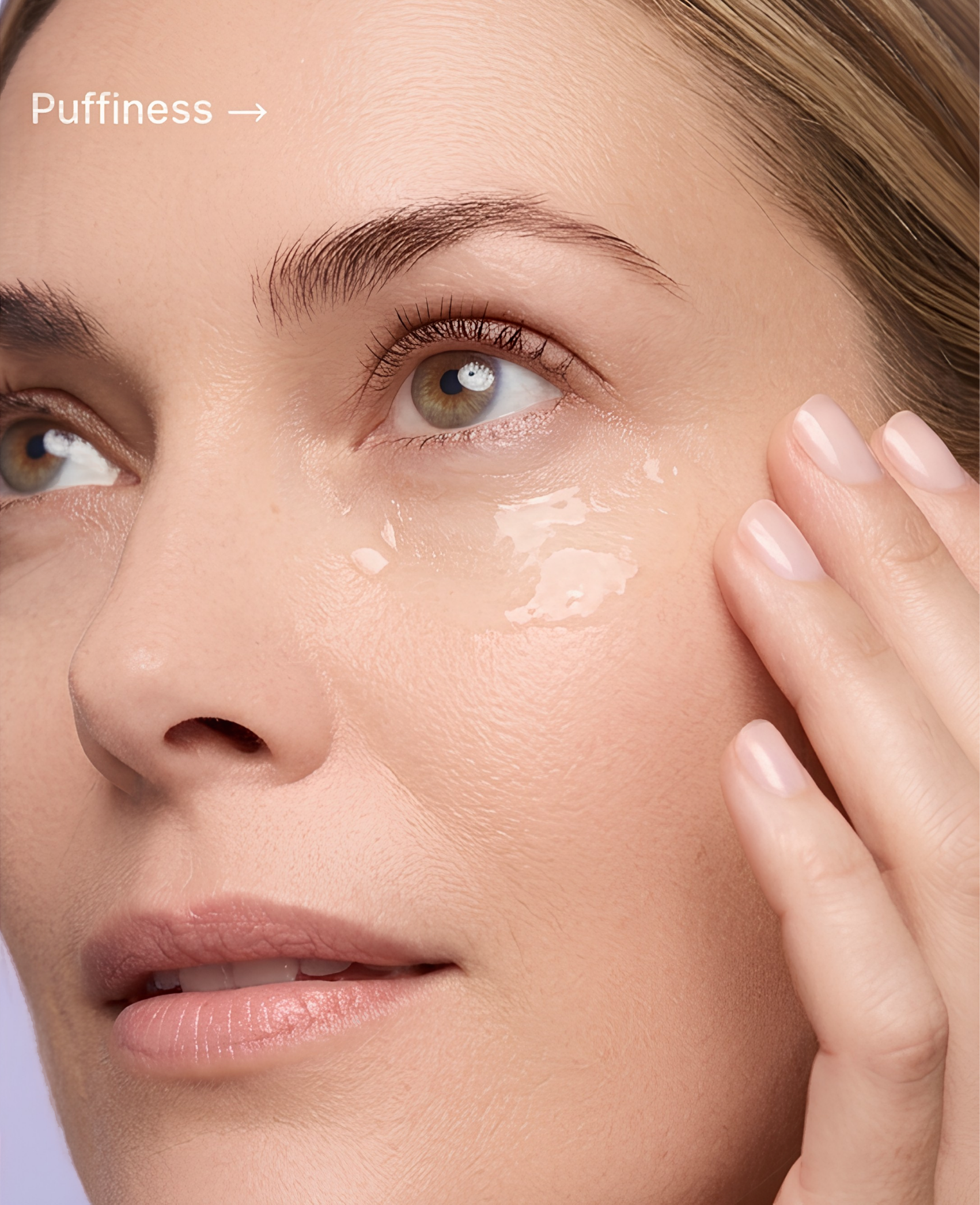 Close-up of a woman's face with a focus on her right eye, eyebrow, and cheek, with her fingers touching her cheek.