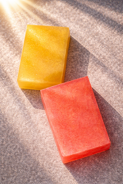 Colorful Artisan Soap bars with sunglasses and This That & Wax tin in sunlight