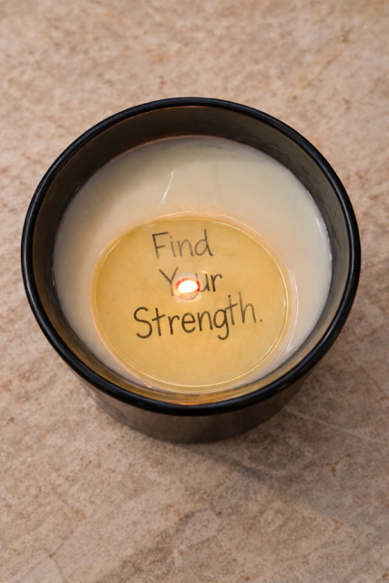 Hidden message candle Find your strength photographed in a black ceramic jar