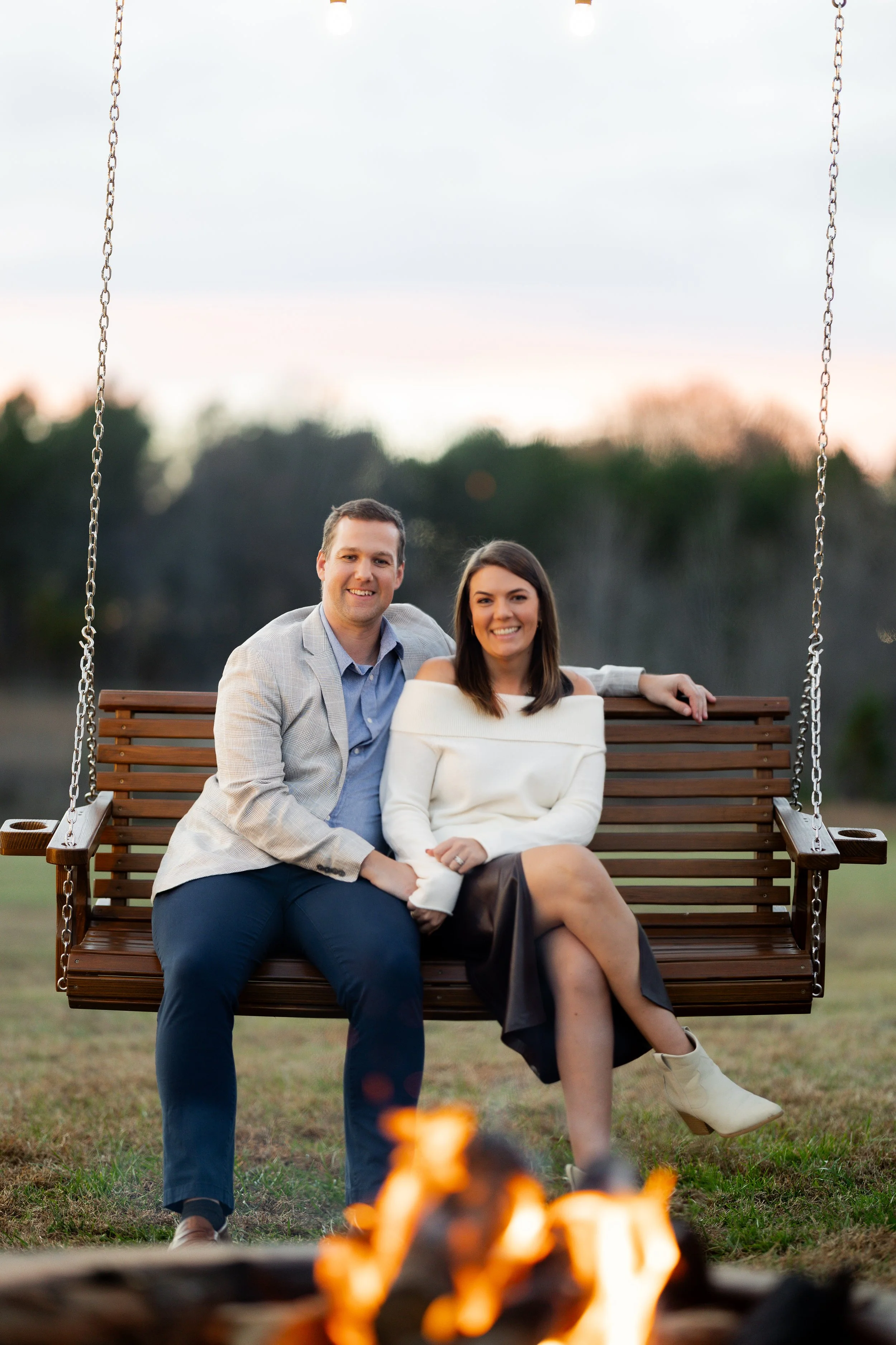 Owners Sara and Blaise Kronenfeld sitting lovingly and admiring their family-owned and operated wedding and event venue at the firepit of sable and vine