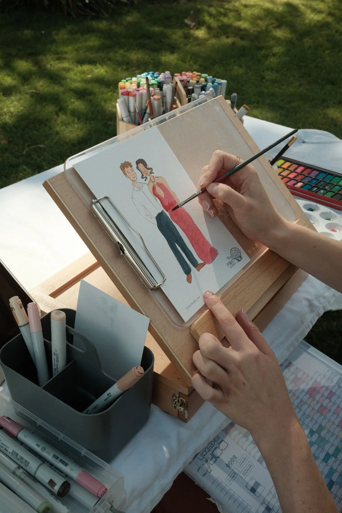 Image depicts artist live illustrating couple at wedding