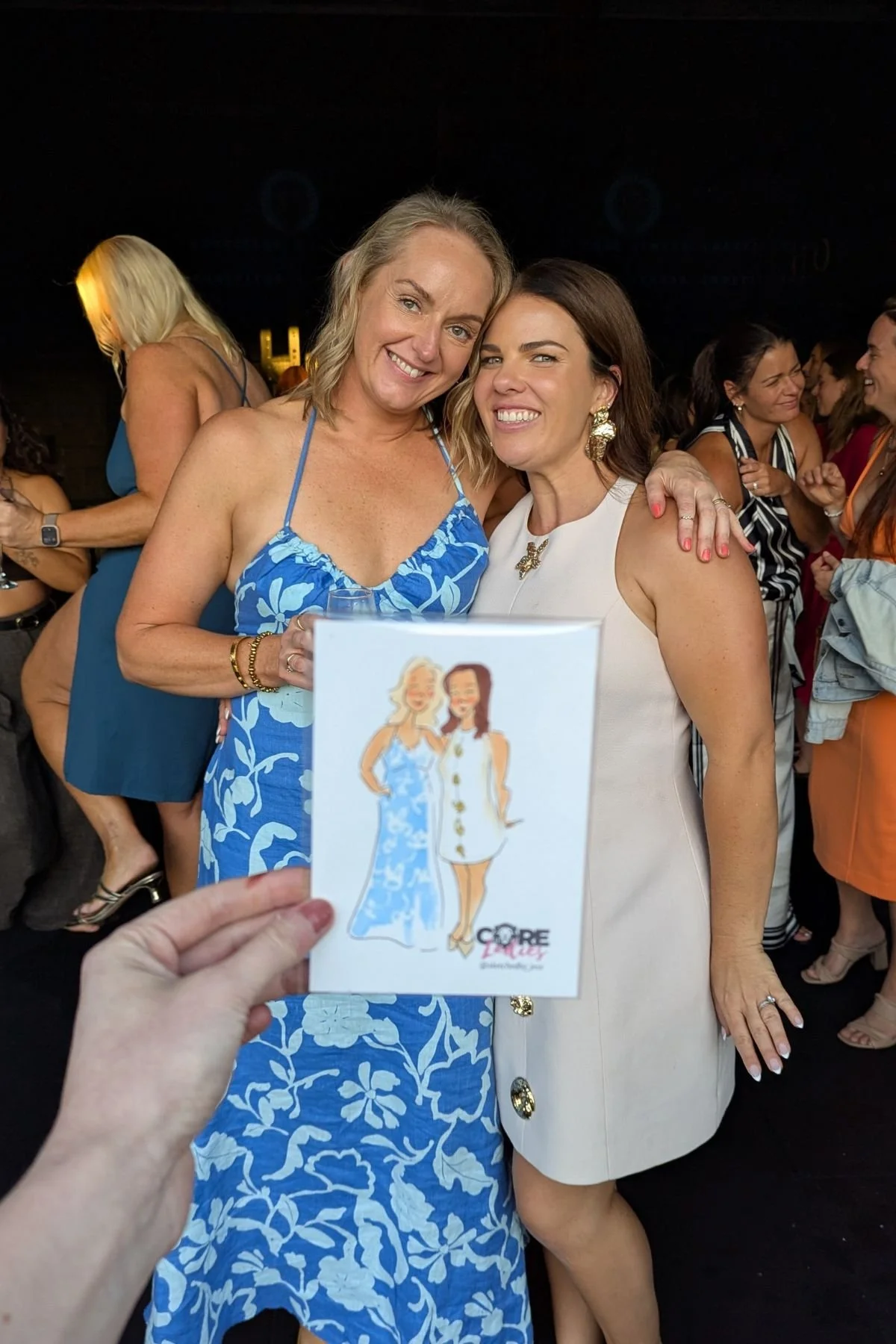 Image depicts women posing with their portrait held out in front of them