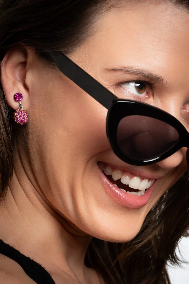 Candice modeling for Alexa Joel, wearing stylish sunglasses and round magenta earrings