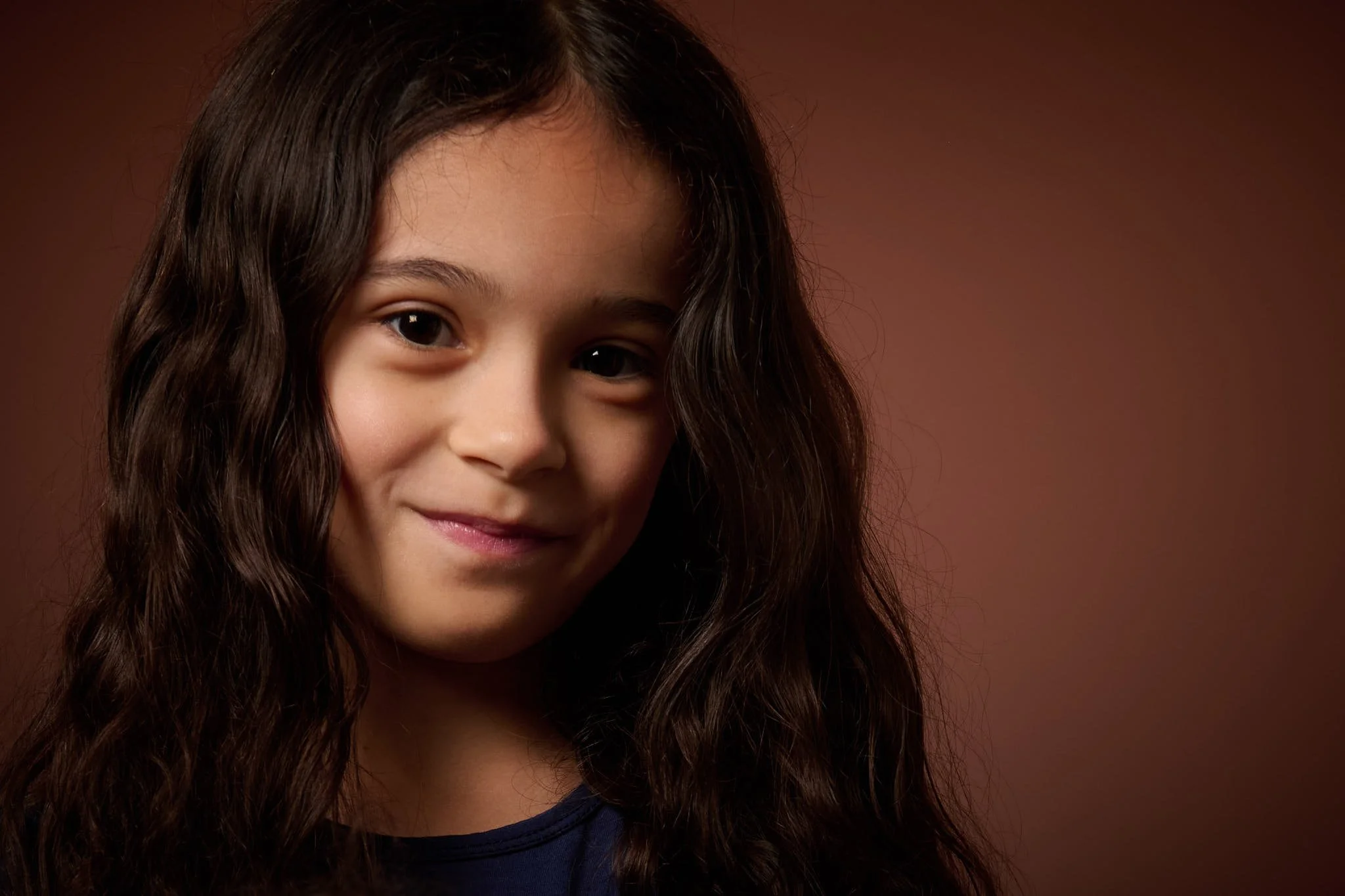 Adorable Athena in soft light backed by a brown background