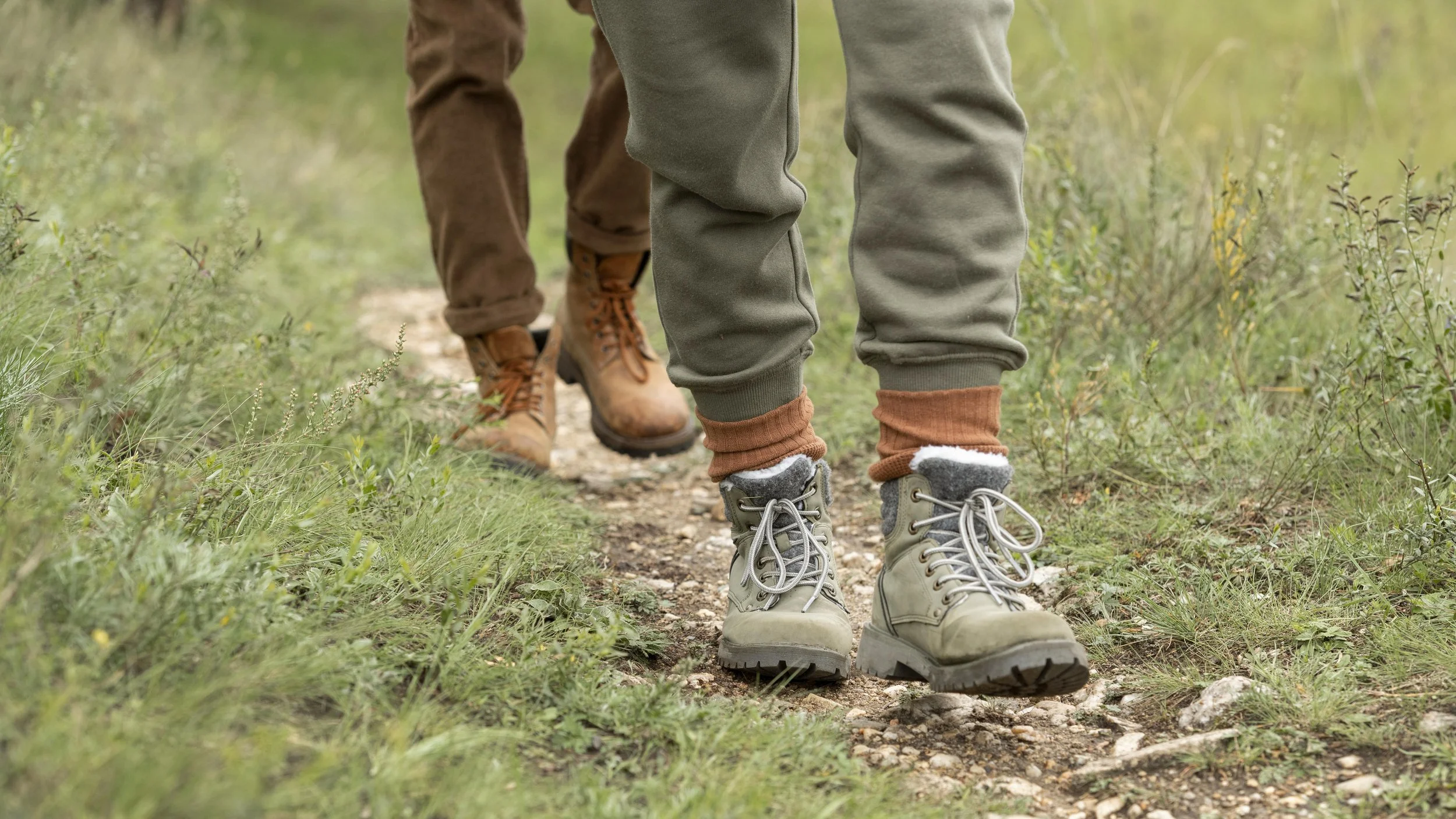 The legs of a couple hiking along a trail