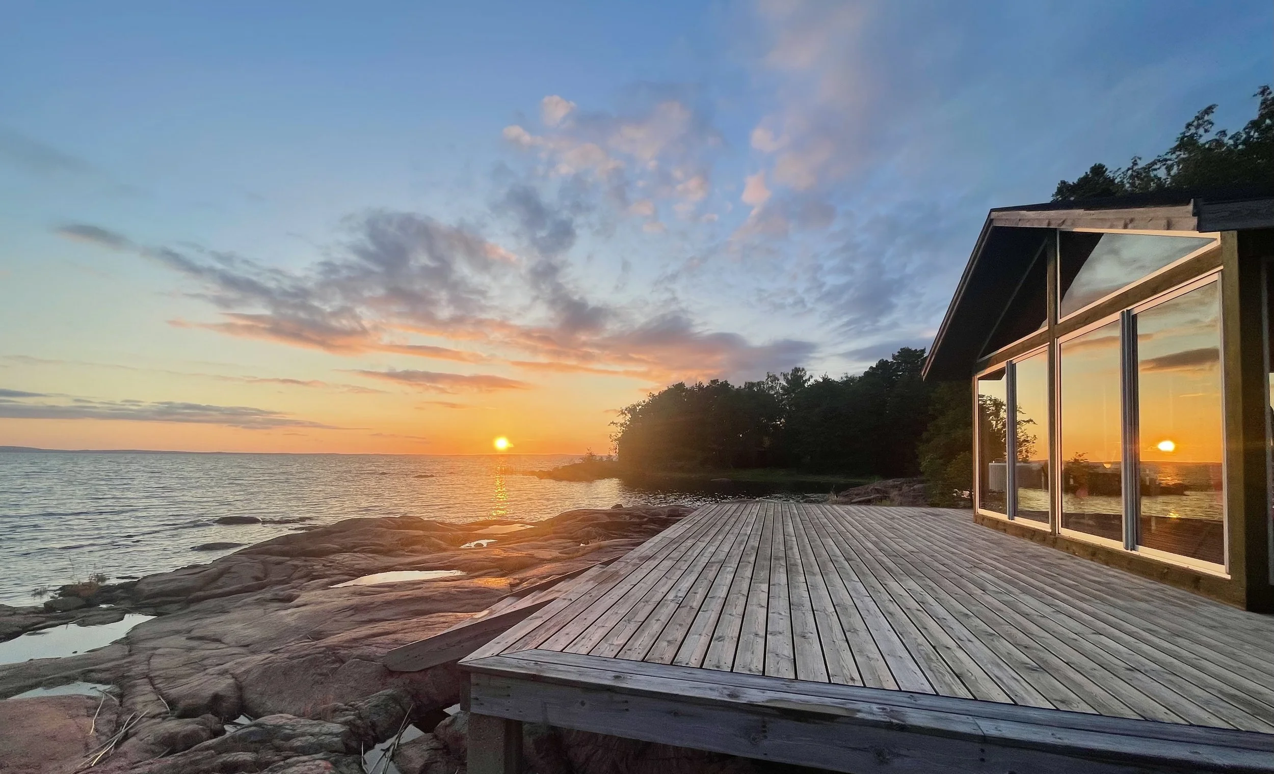 a house with a deck at sunset